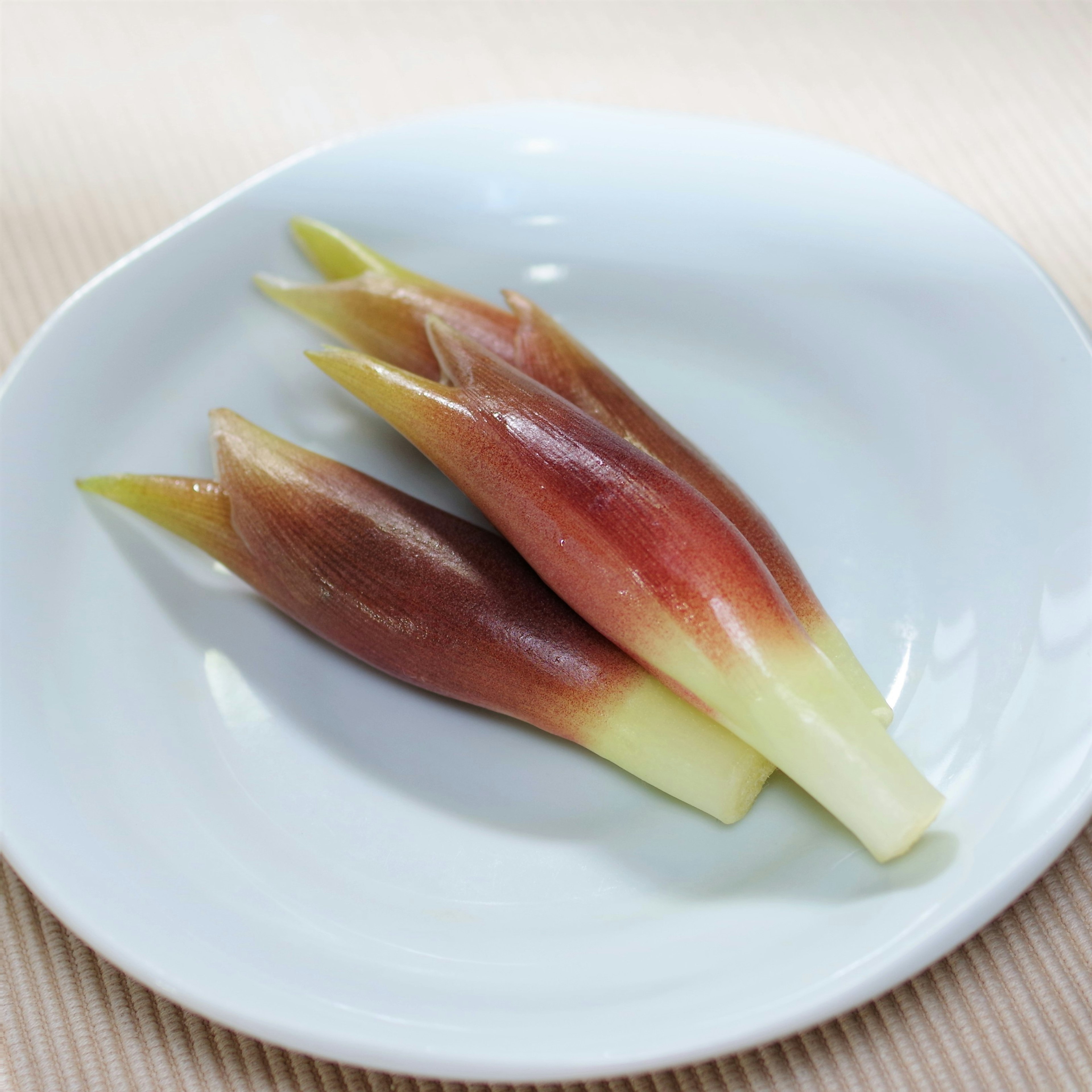 Fresh vegetable buds arranged on a white plate