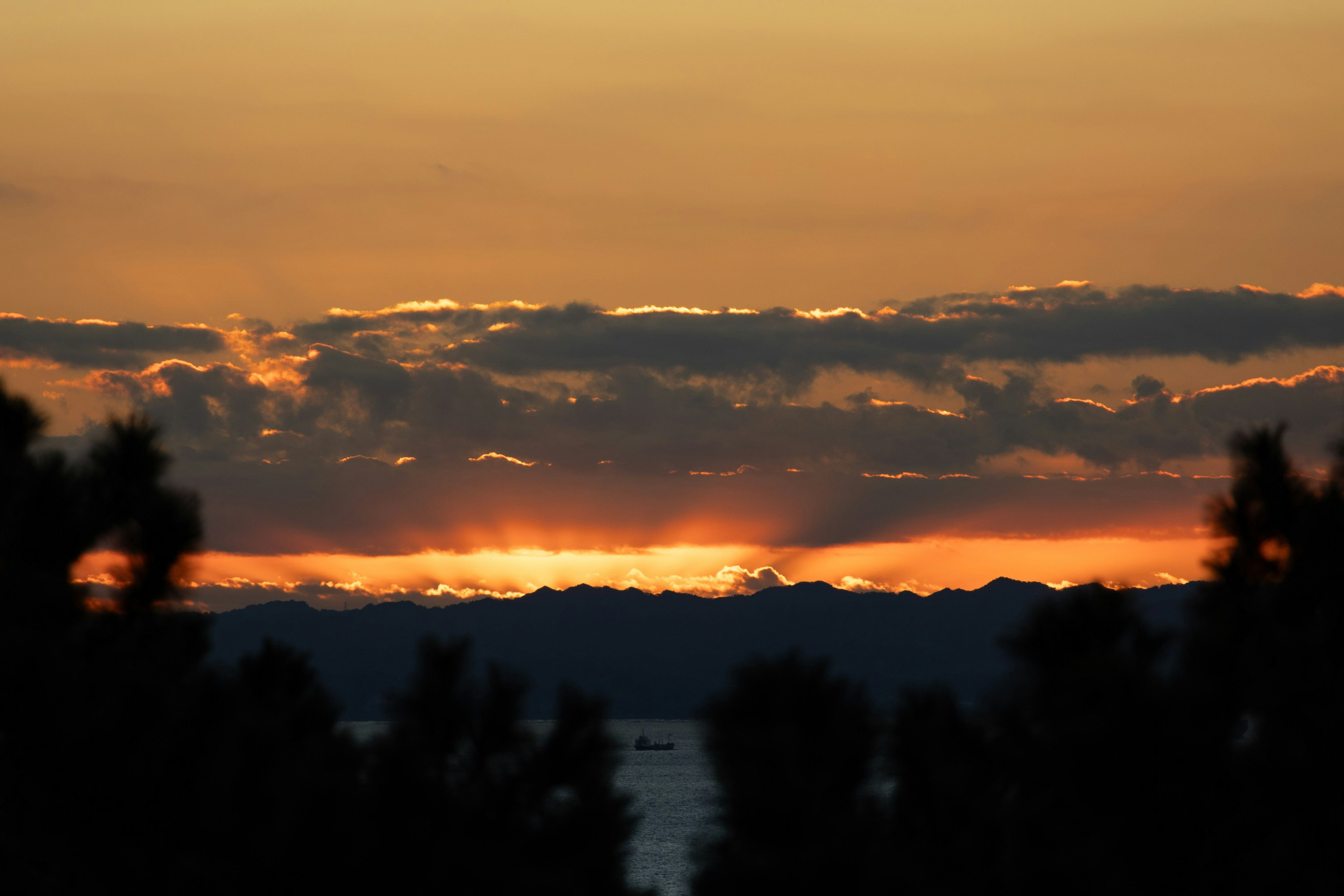夕焼けの空とシルエットの山々が見える風景