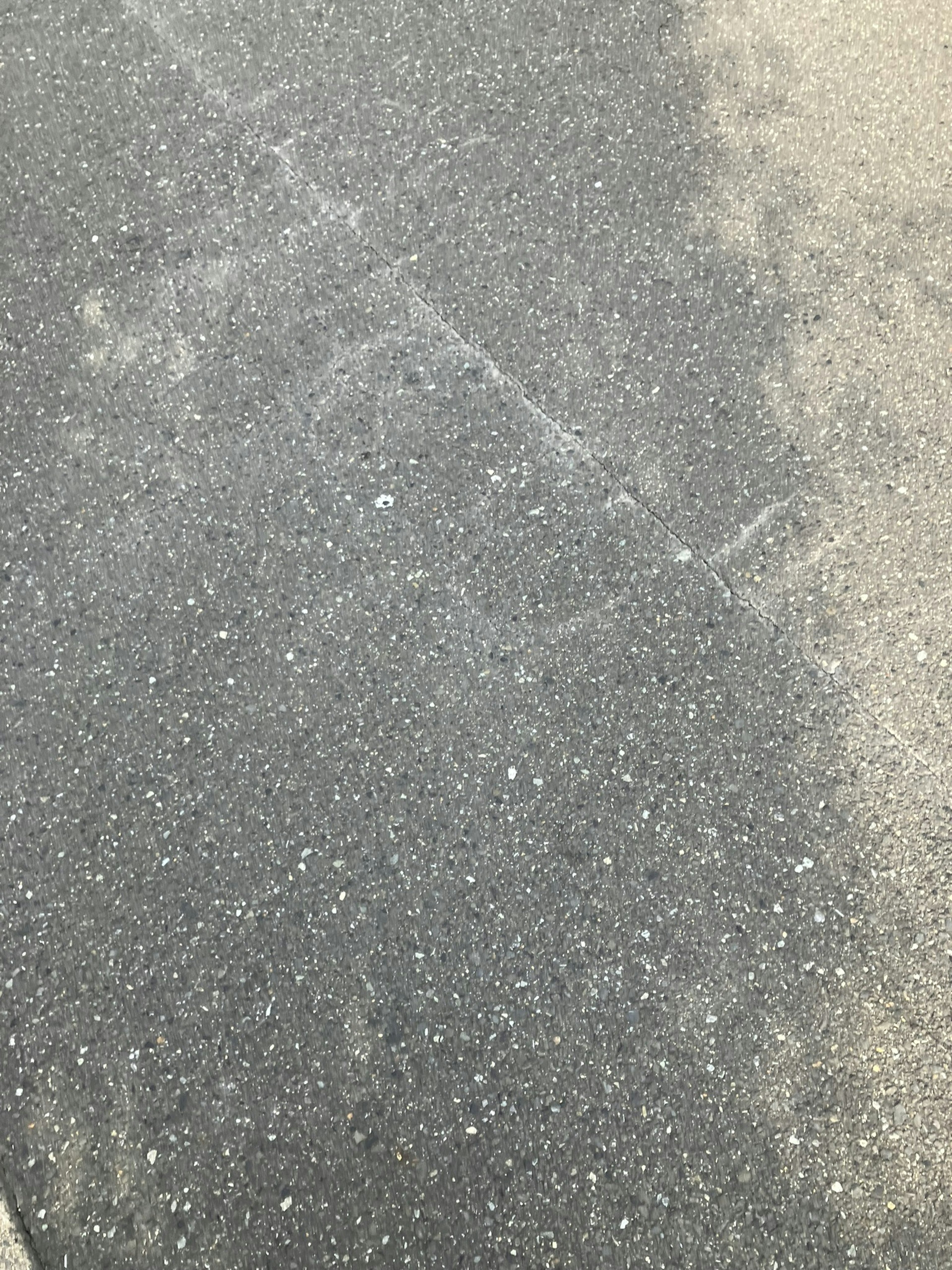 Close-up of a textured asphalt surface showing different shades