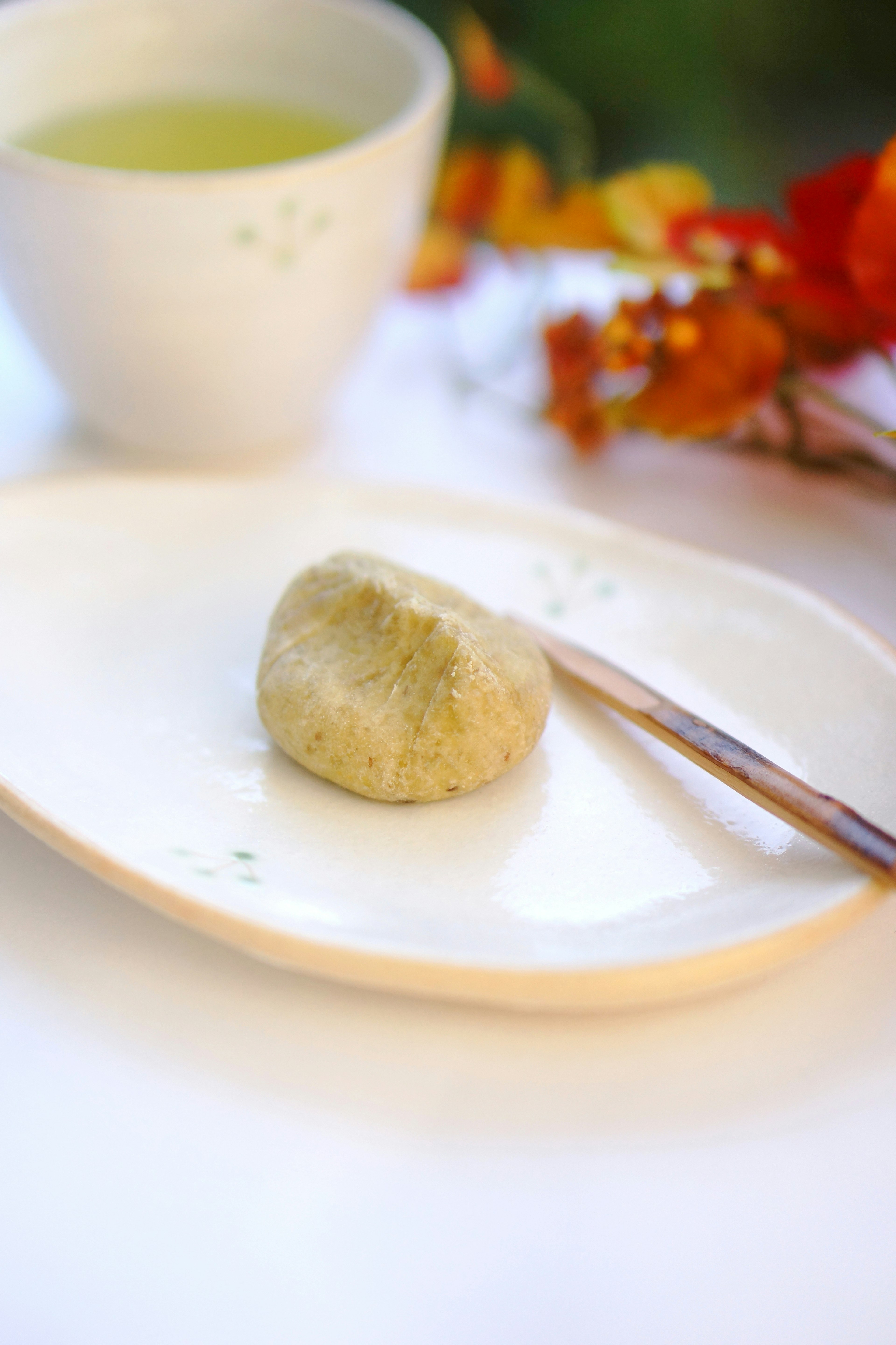 Une assiette simple avec du matcha et un morceau de wagashi accompagné d'une tasse de thé vert