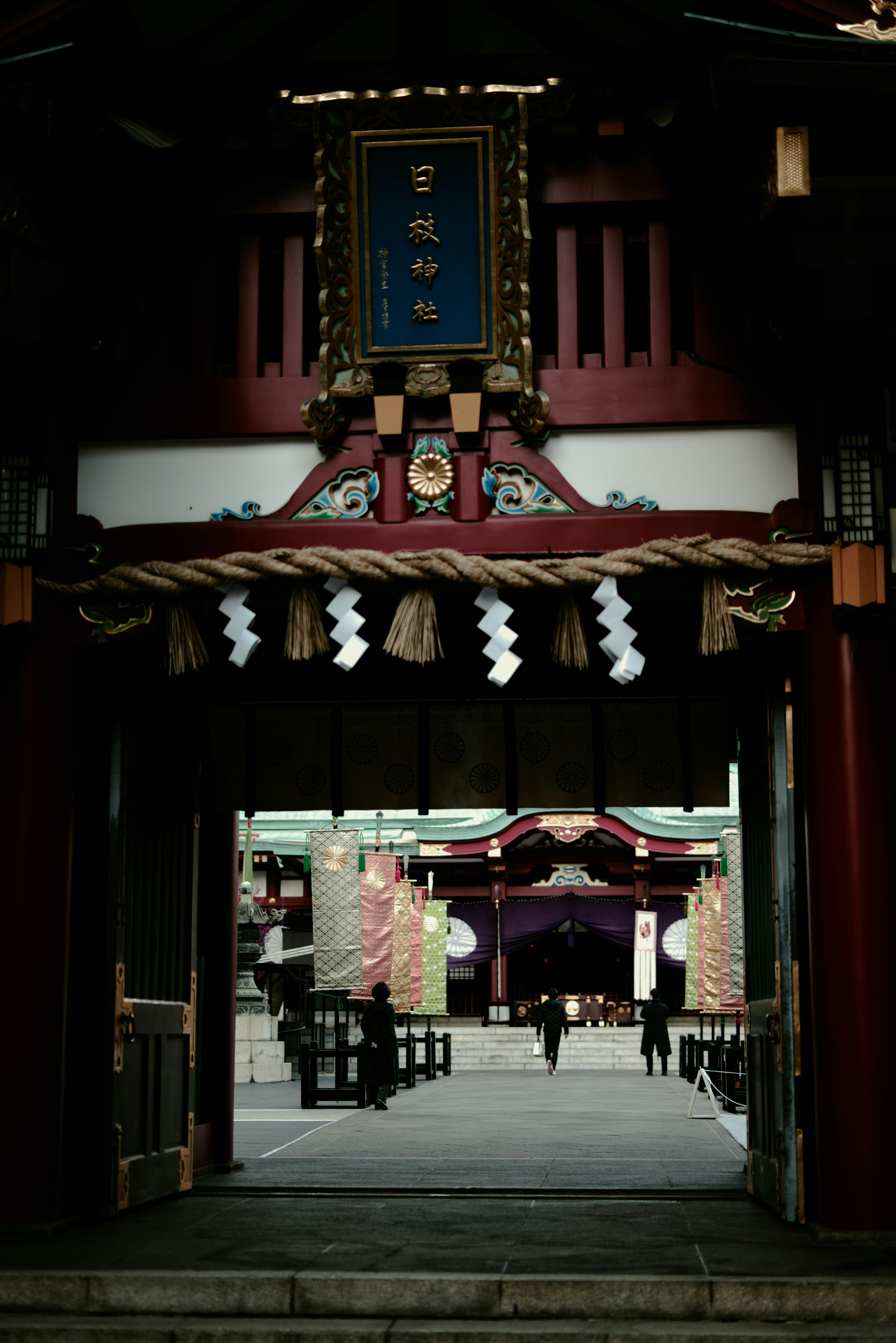 Traditional Japanese gate with a shrine visible in the background