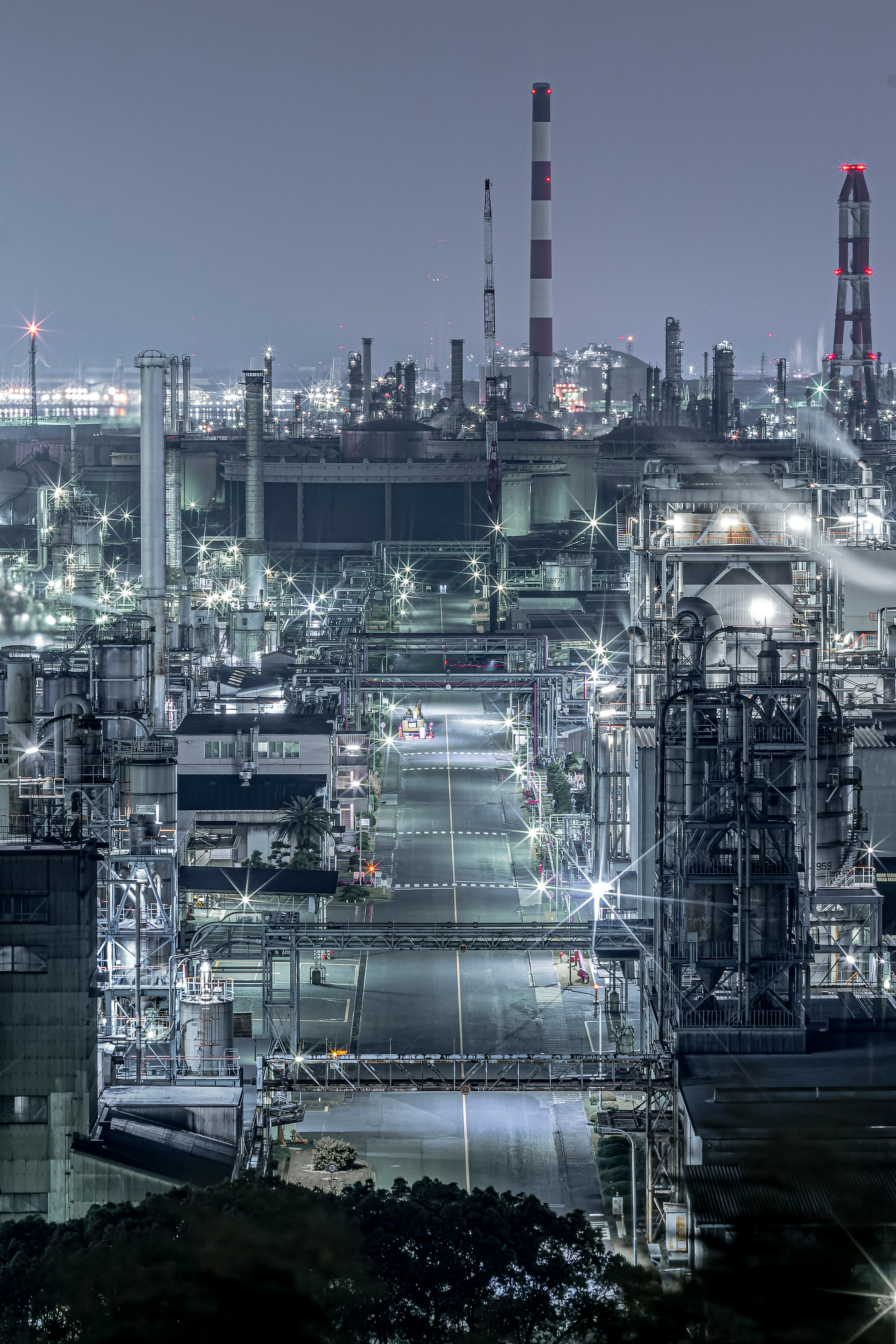 Vista notturna di un'area industriale con fabbriche e ciminiere