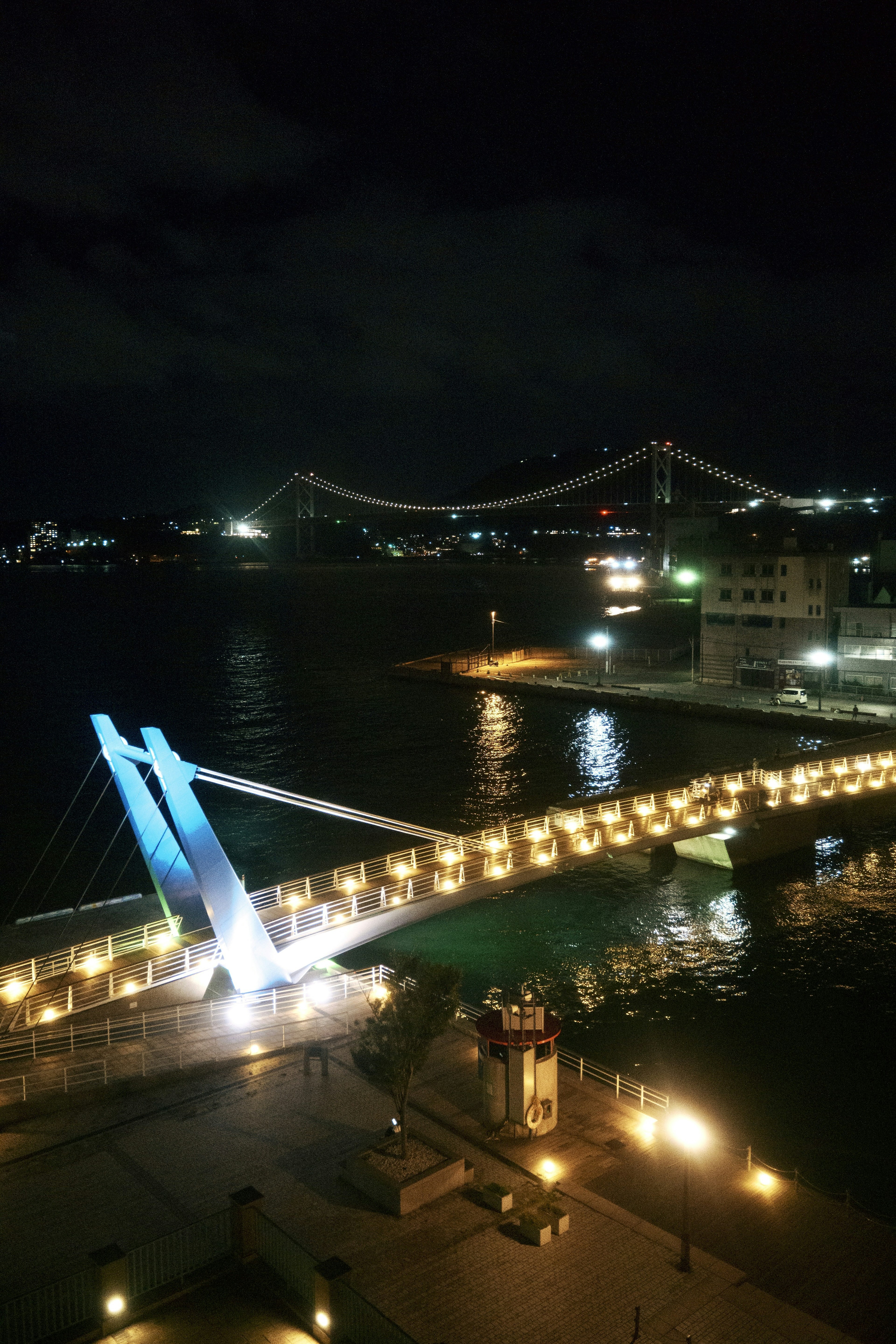 Malersicher Blick auf eine bei Nacht beleuchtete Brücke mit Wasserreflexionen