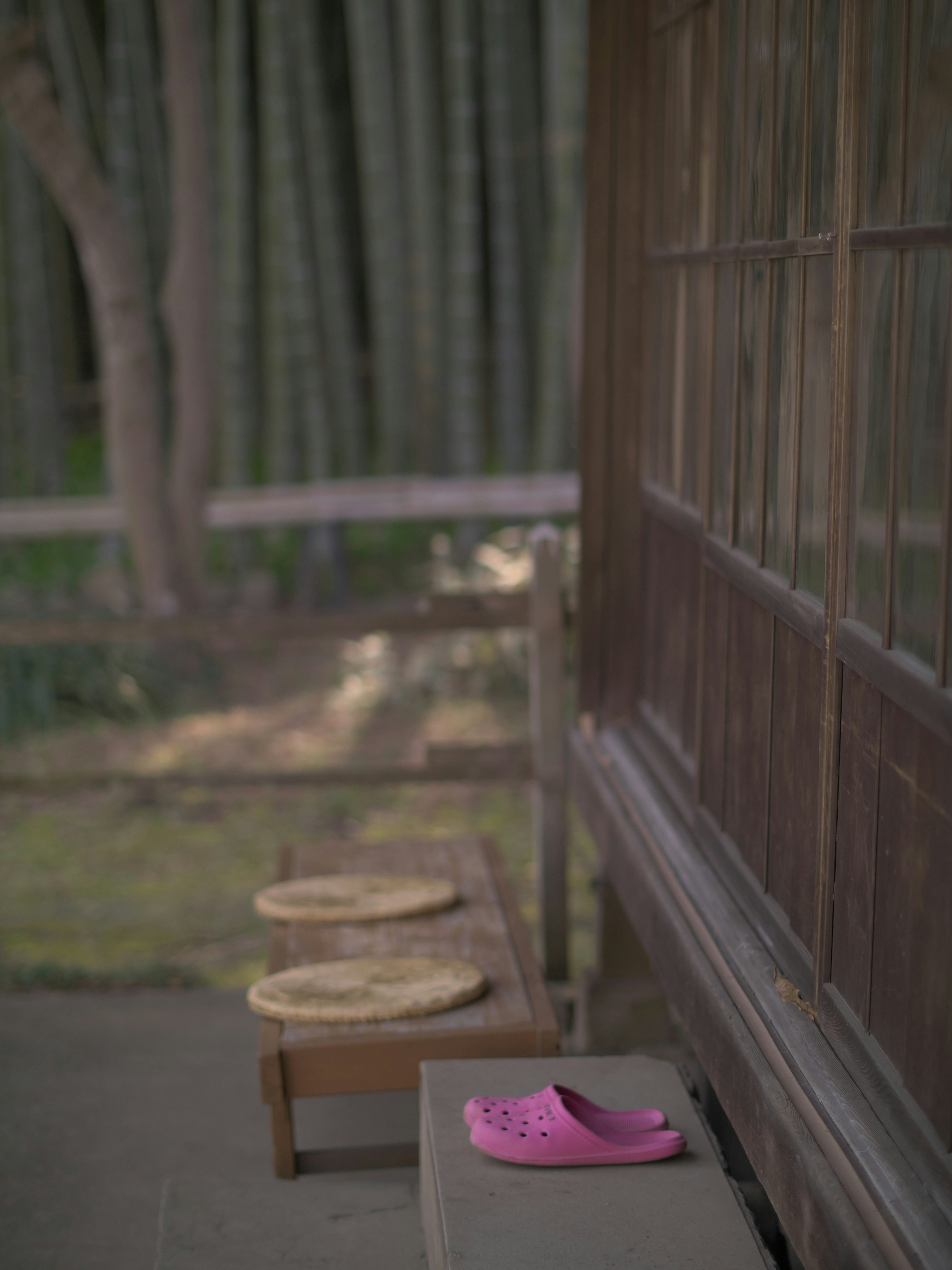 Eksterior rumah tradisional Jepang dekat hutan bambu dengan sandal pink