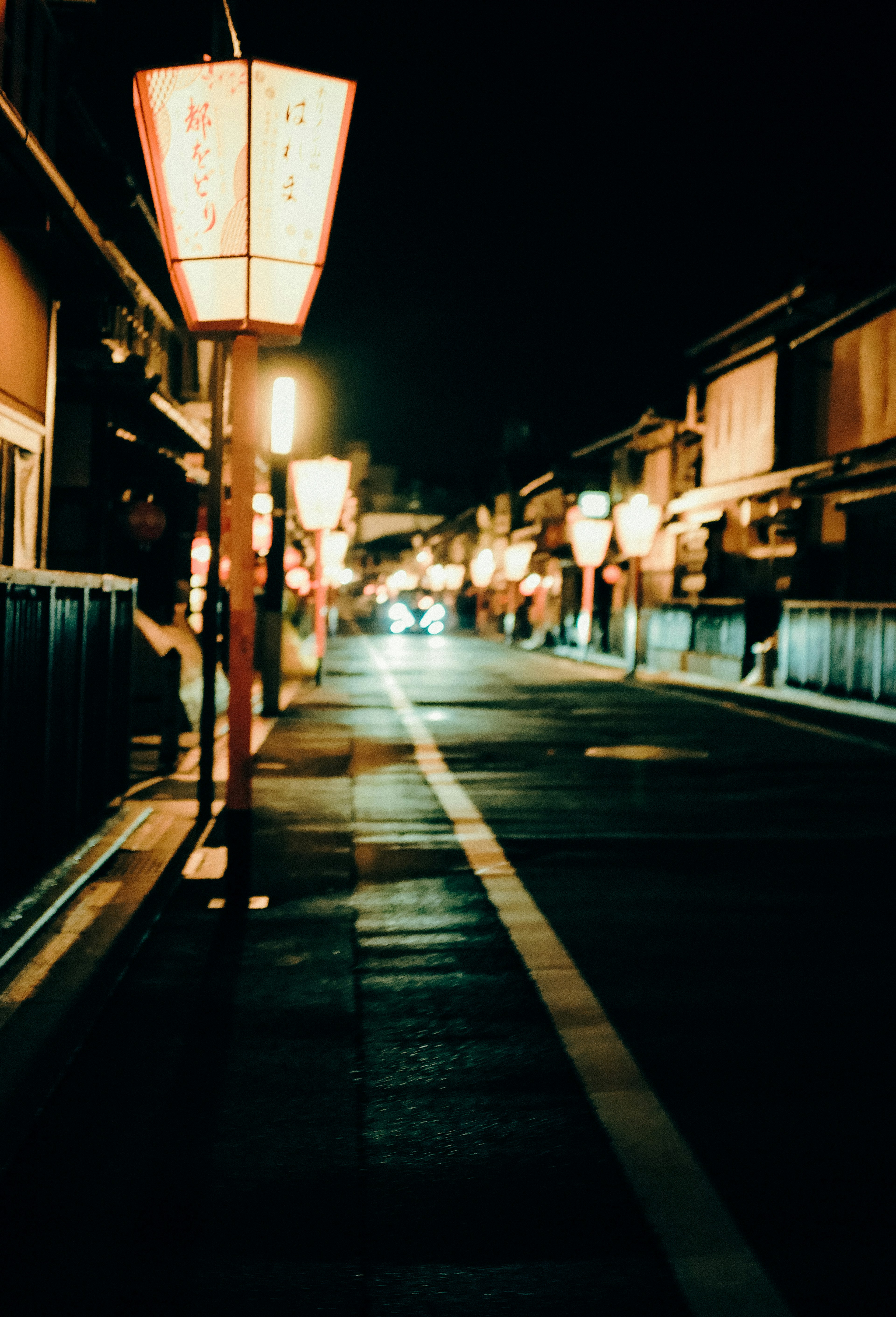 Scena notturna di una strada con lanterne illuminate lungo il percorso