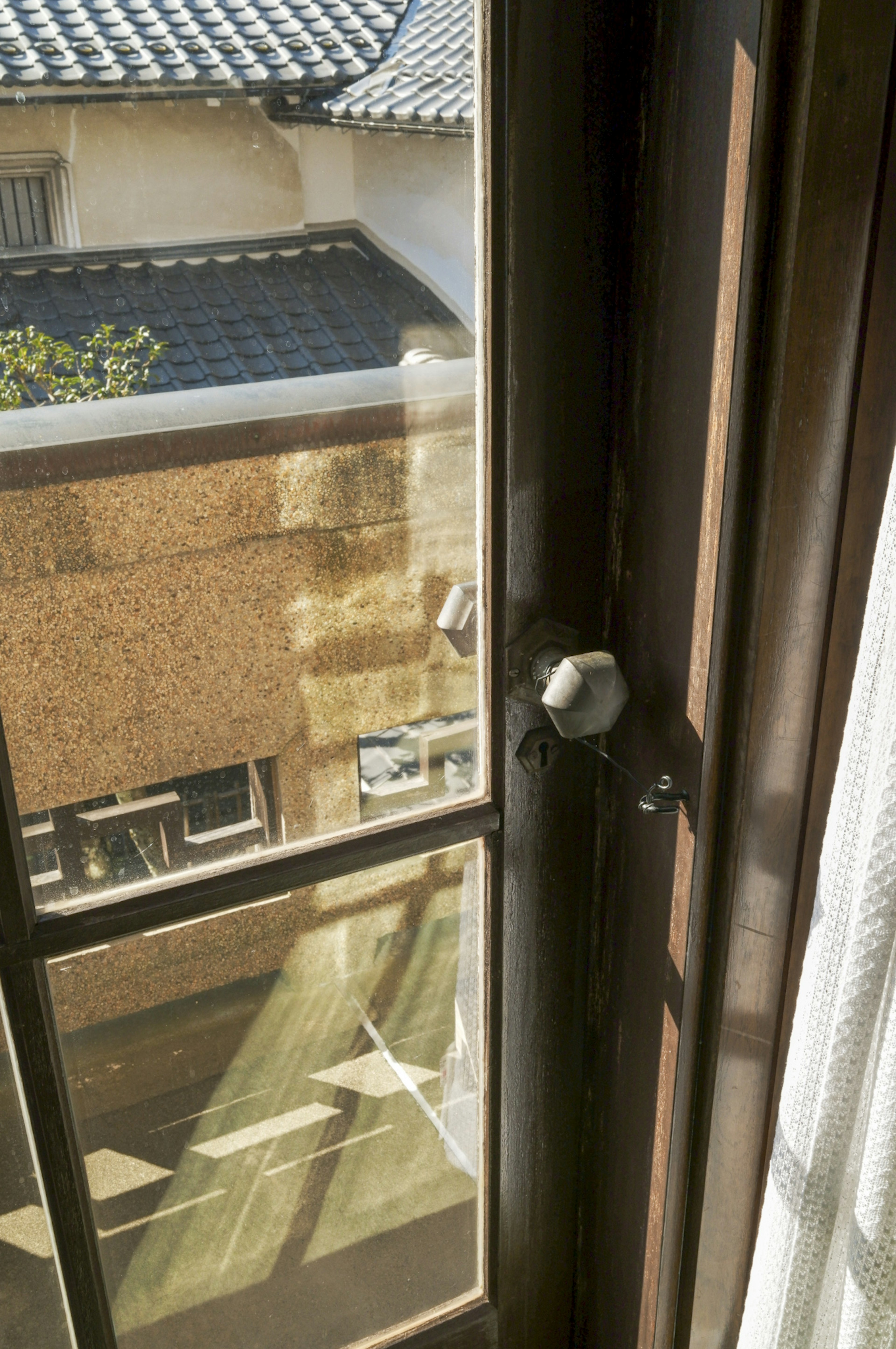 Blick aus einem Fenster auf ein traditionelles japanisches Gebäude und Sonnenlicht