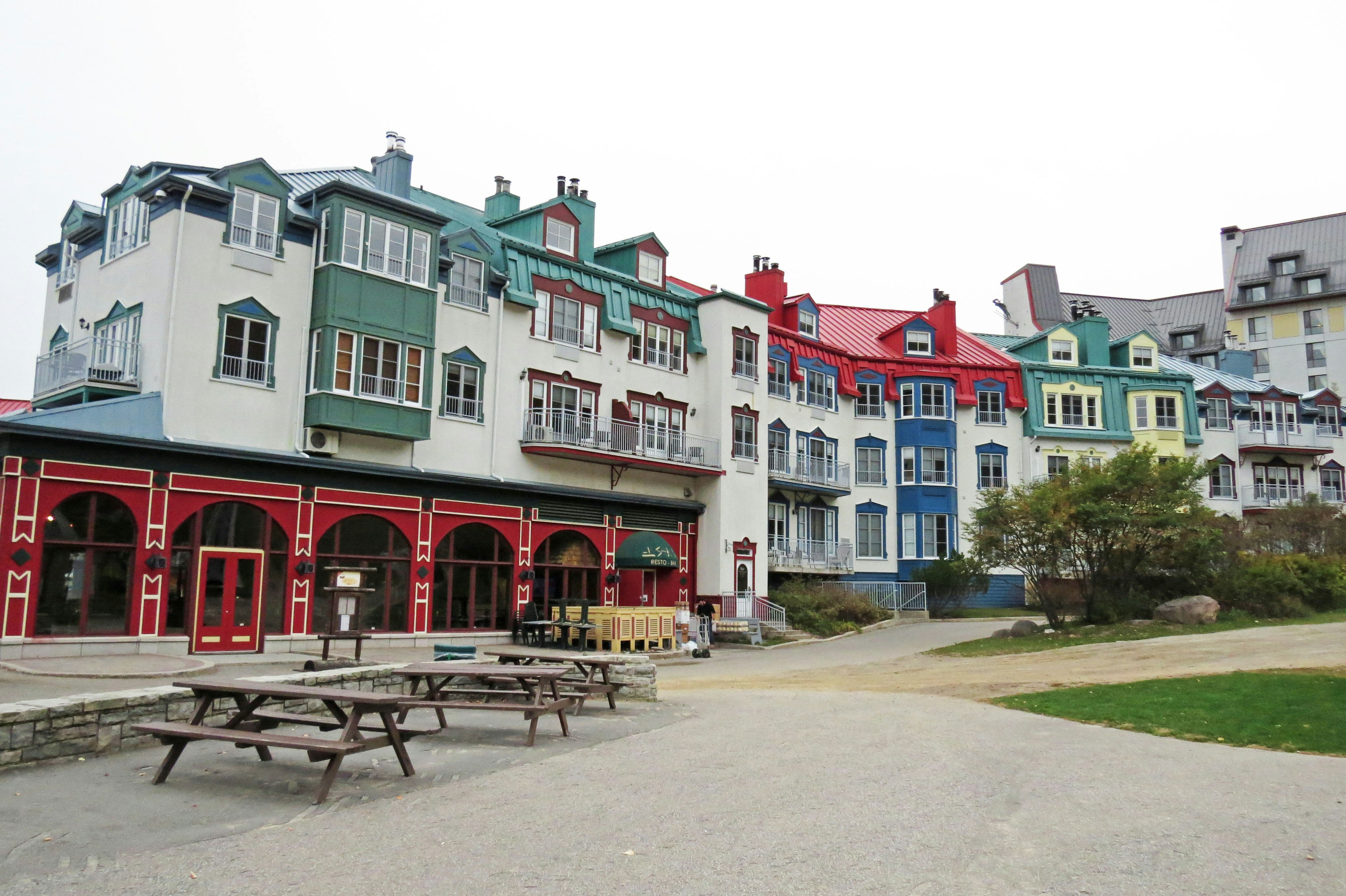 Bâtiments colorés avec des tables de pique-nique en extérieur dans un paysage pittoresque