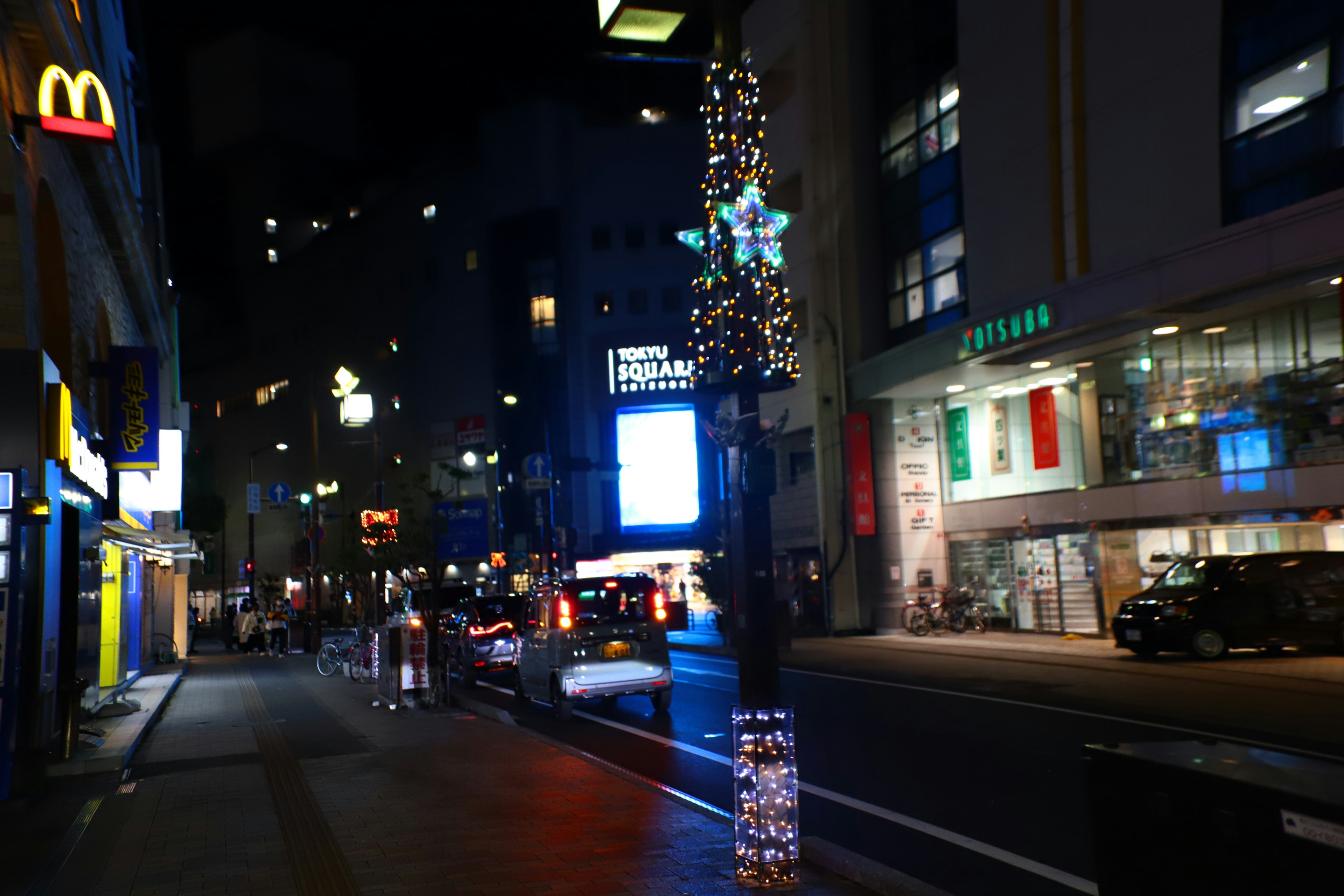 Night city street adorned with lights and McDonald's sign