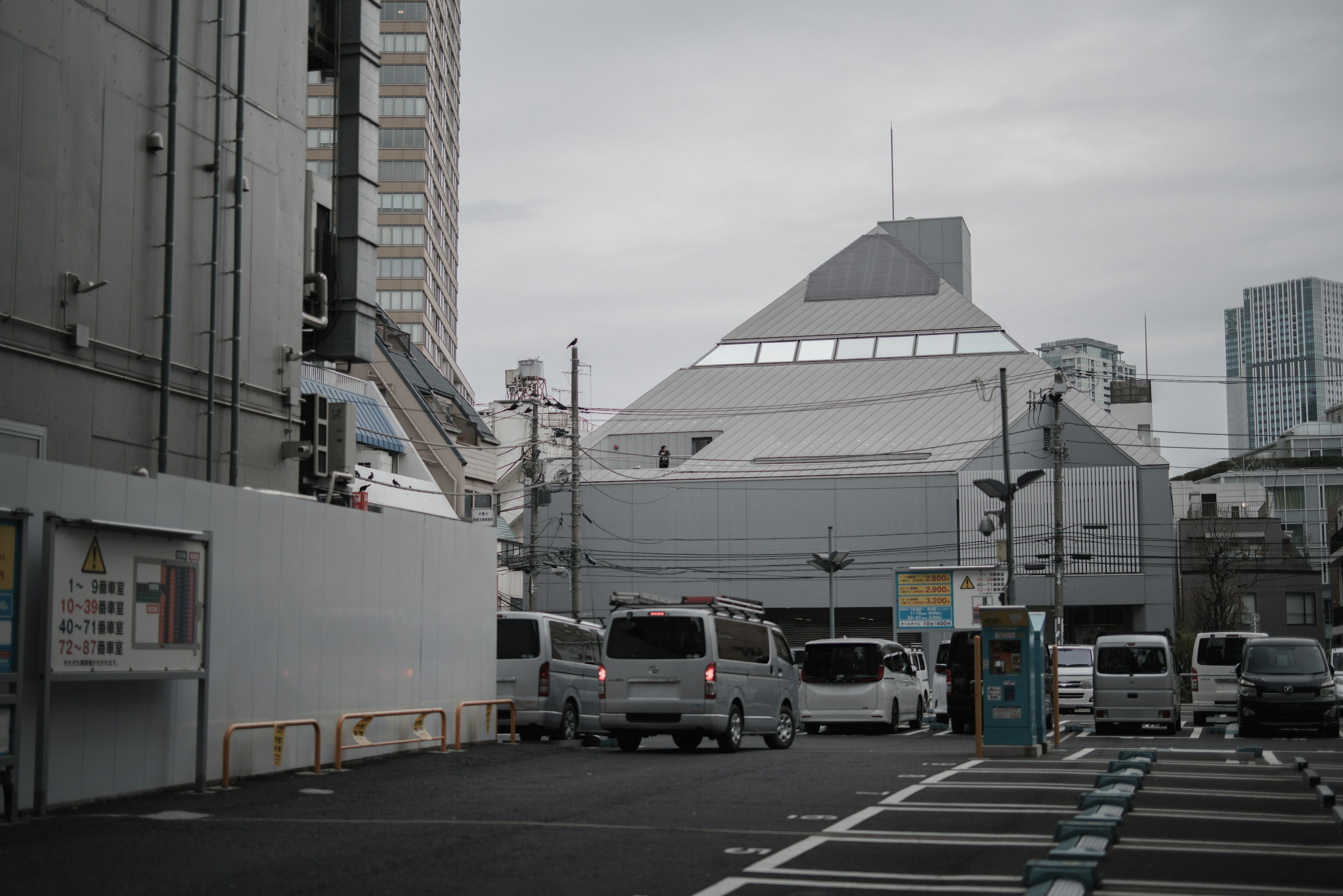 灰色の空の下にある近代的な建物と車両の風景