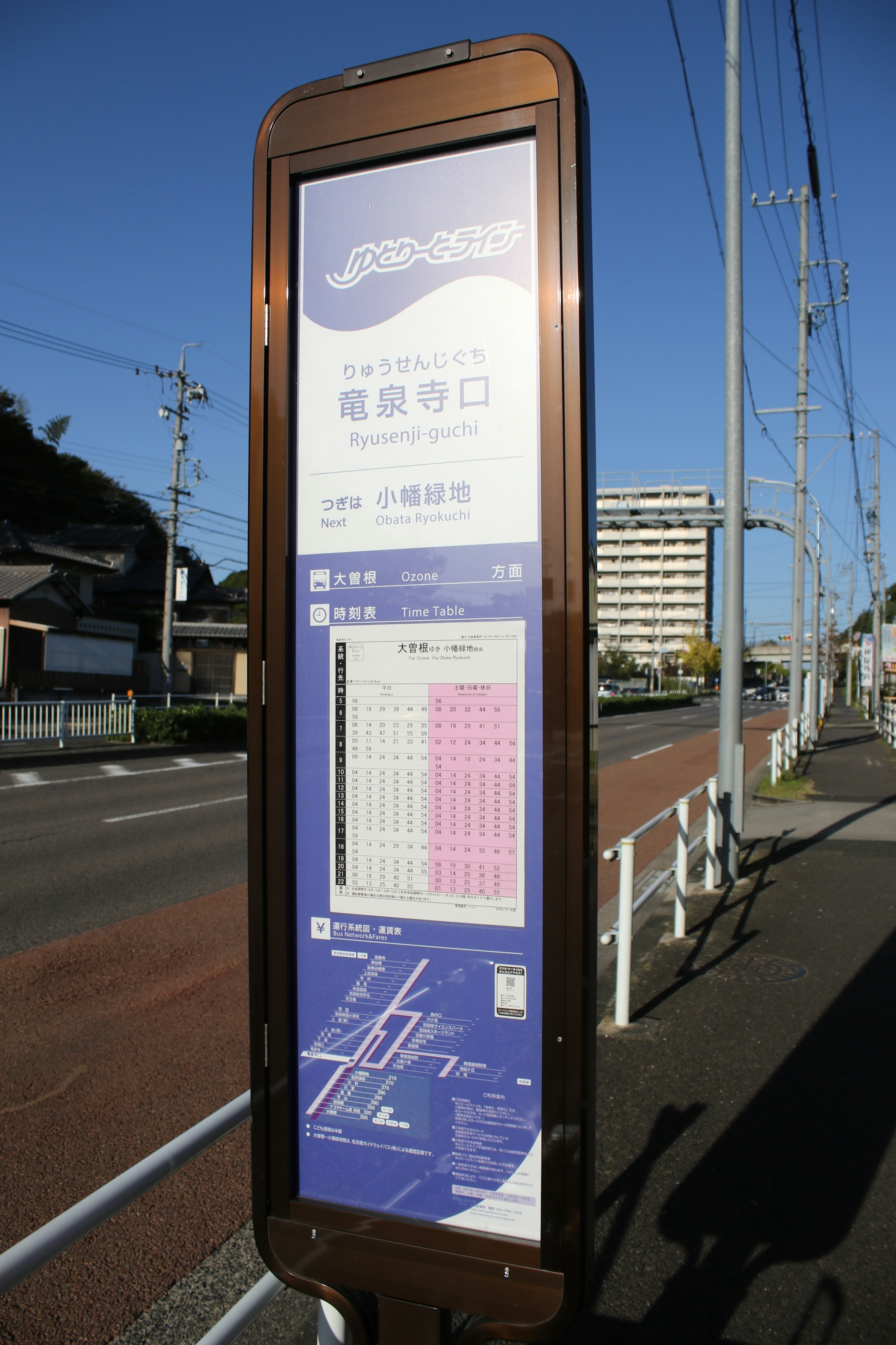 Haltestelleninformationsschild mit Fahrplan unter blauem Himmel