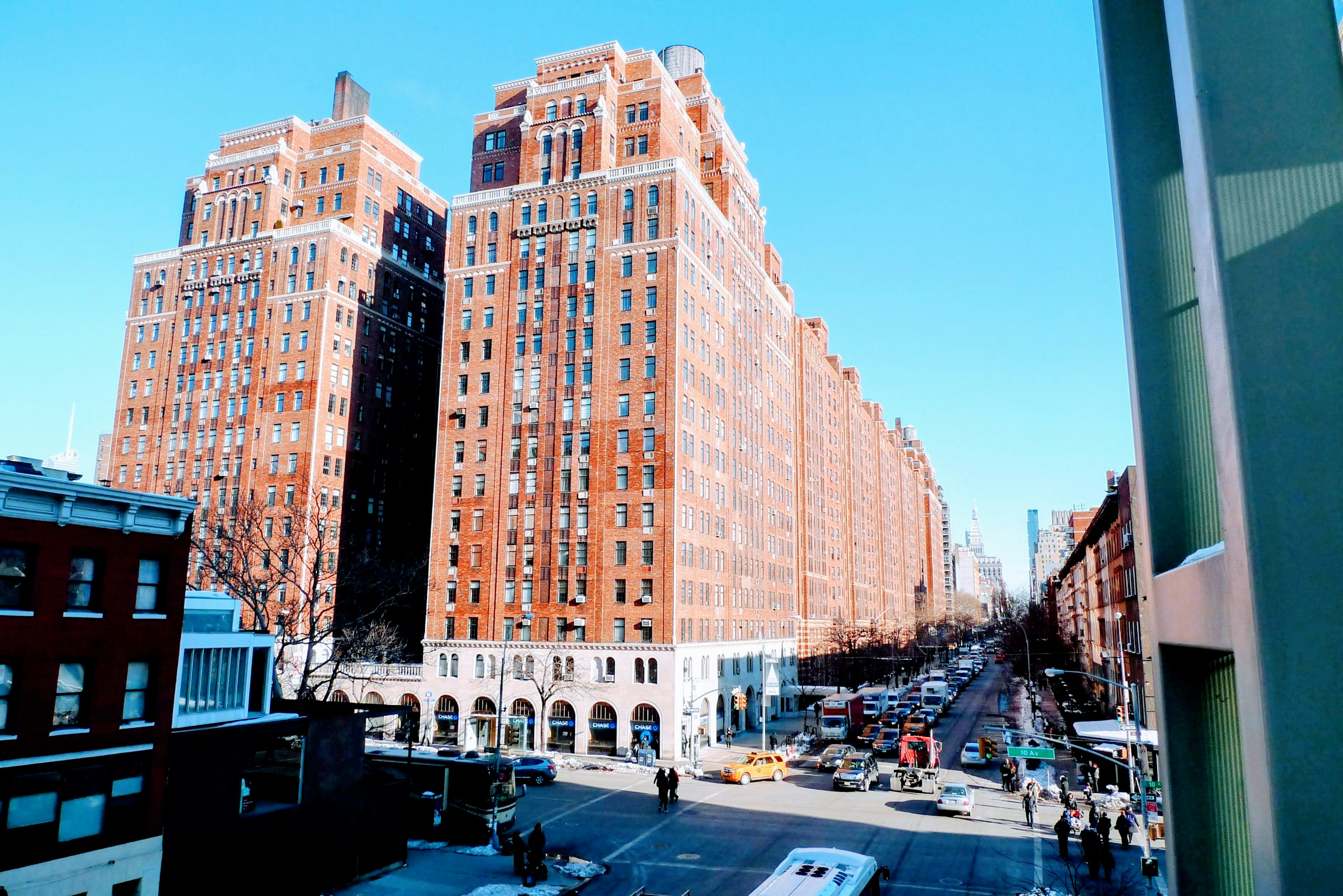 Historic brick buildings towering under a blue sky with a street view