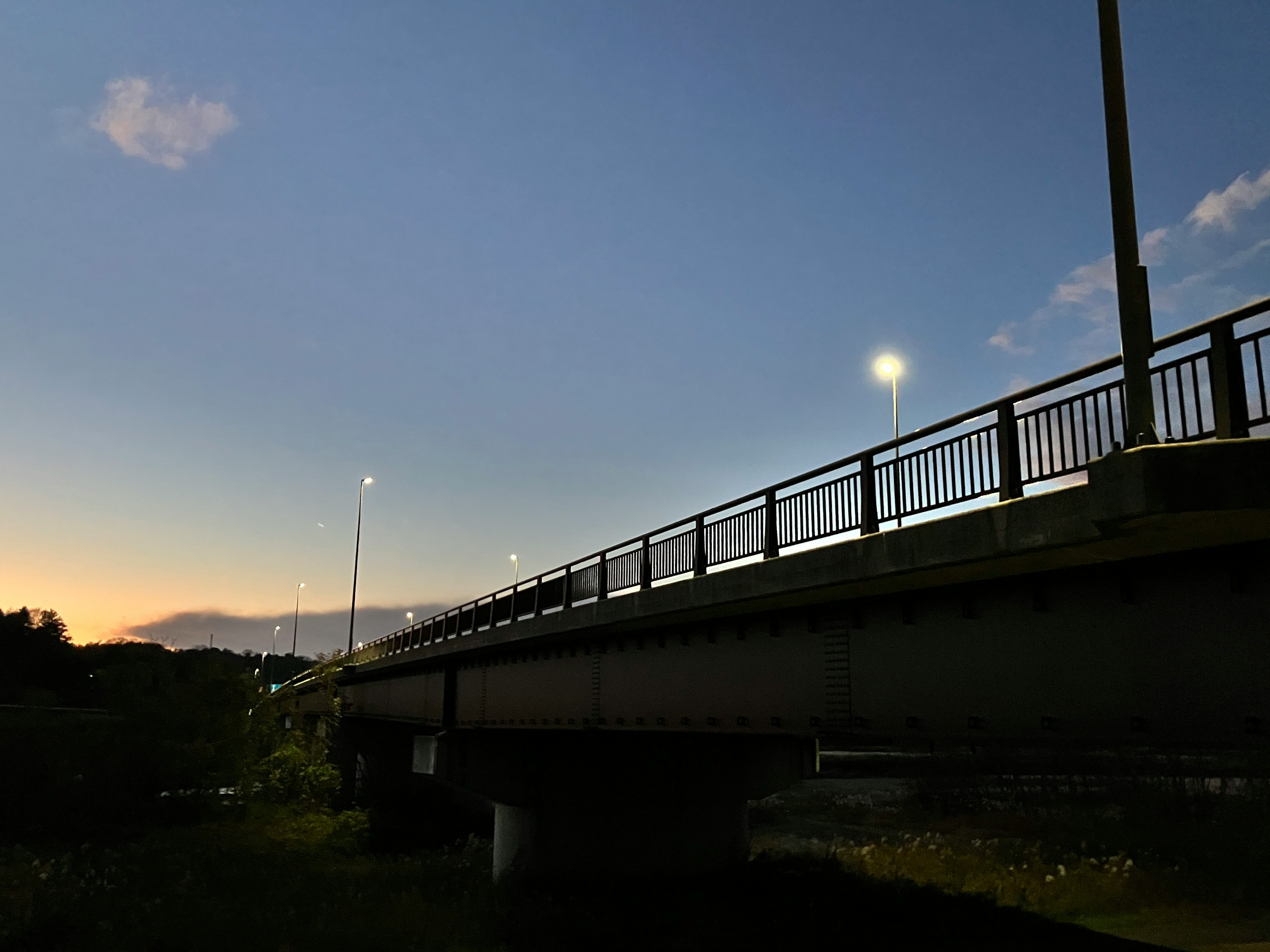 夕暮れ時の橋のシルエットと街灯