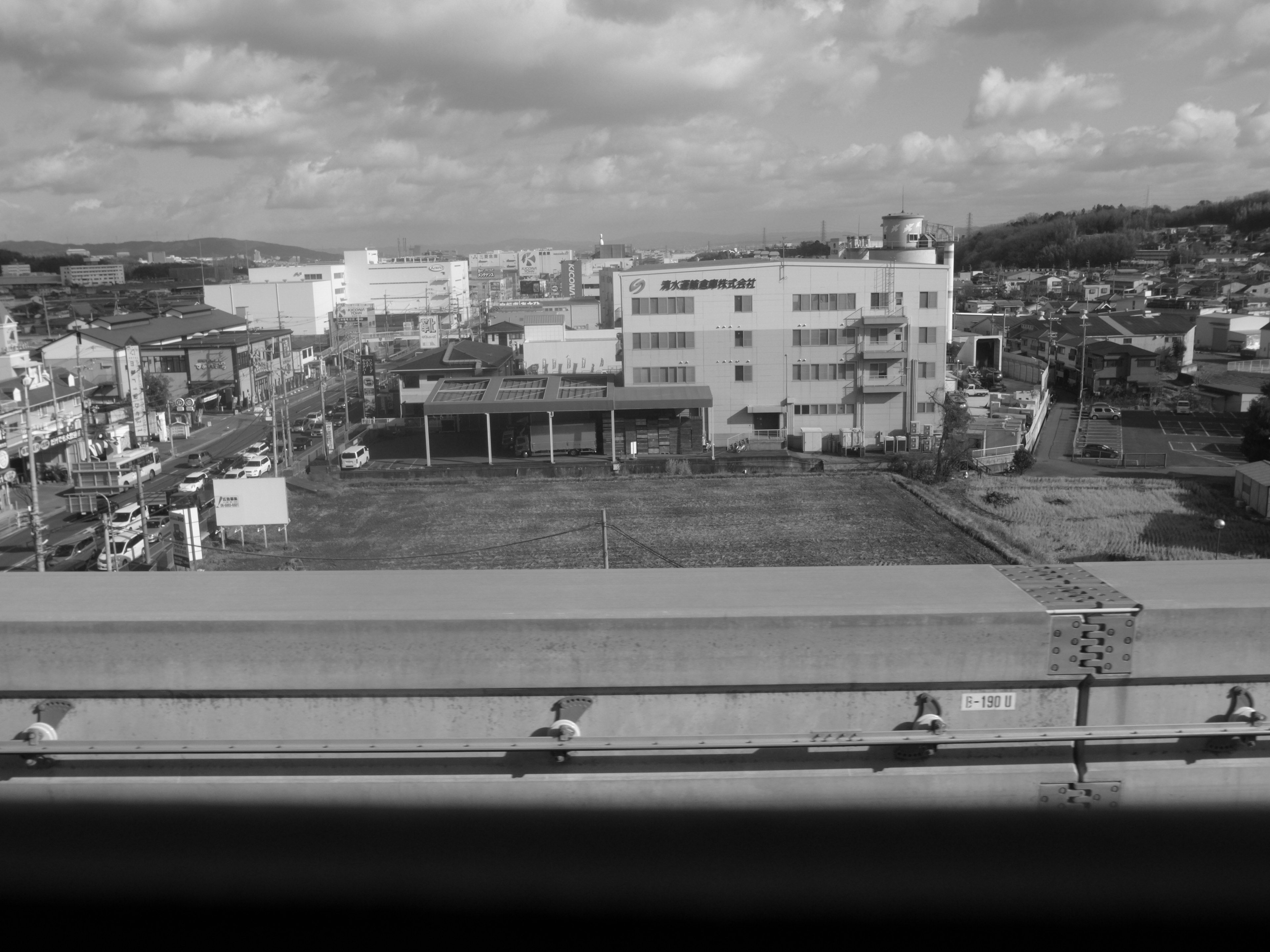 Paisaje urbano en blanco y negro con edificios y un estacionamiento