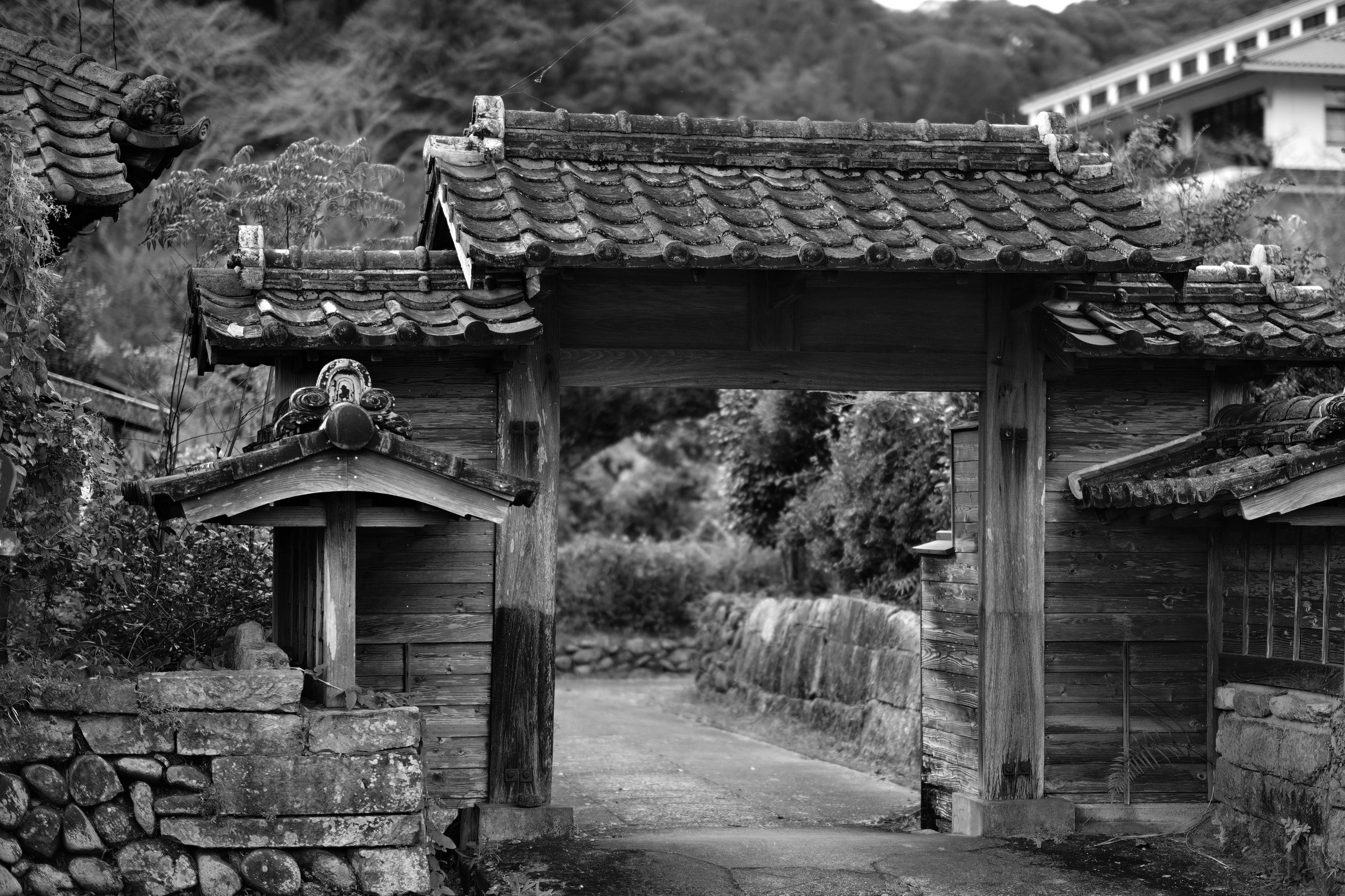 古い木製の門と石造りの壁のある日本の田舎の風景