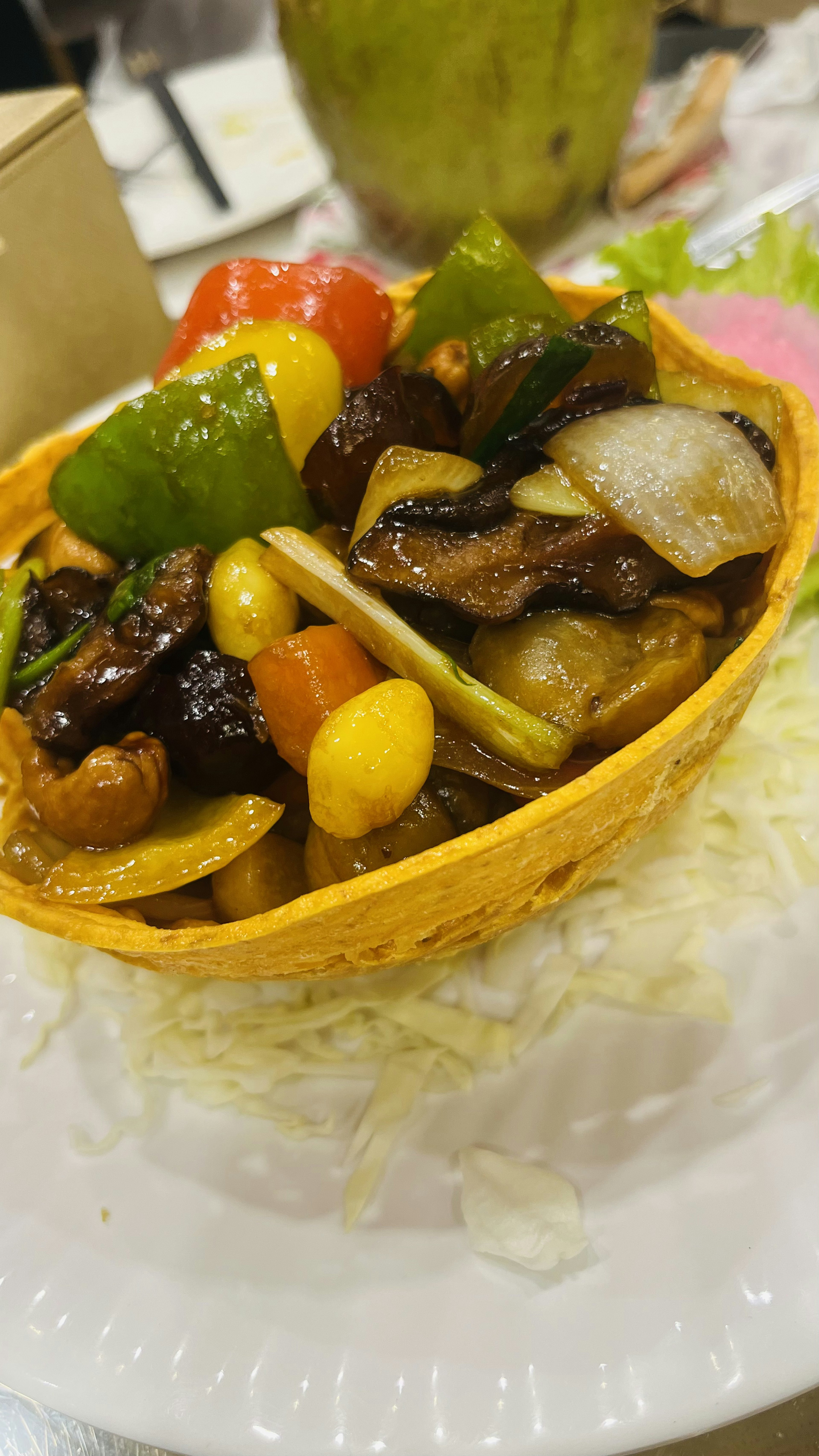 カラフルな野菜と肉の炒め物が盛り付けられた食べられるバスケット