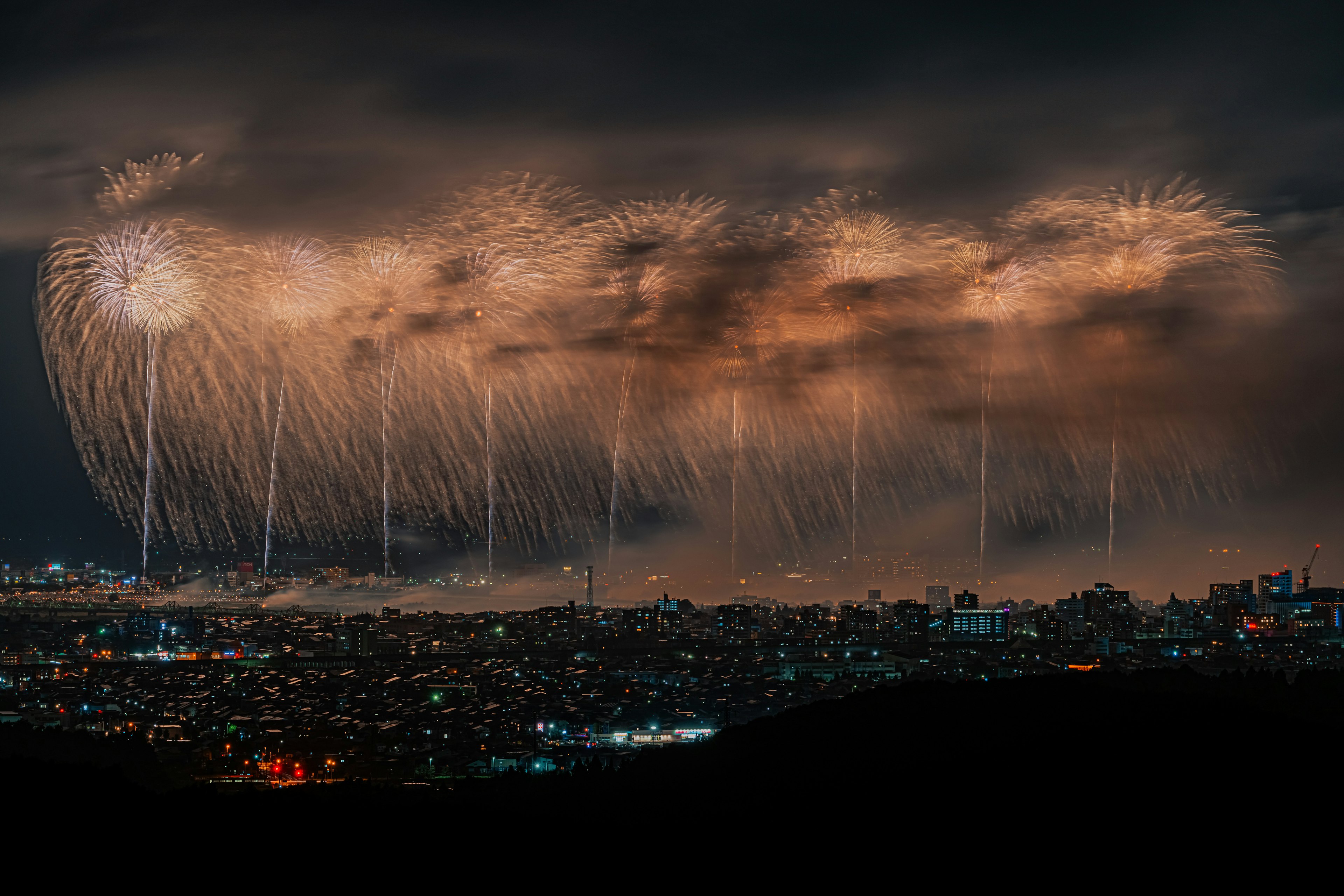 Spettacolare spettacolo di fuochi d'artificio che illumina il cielo notturno su una città