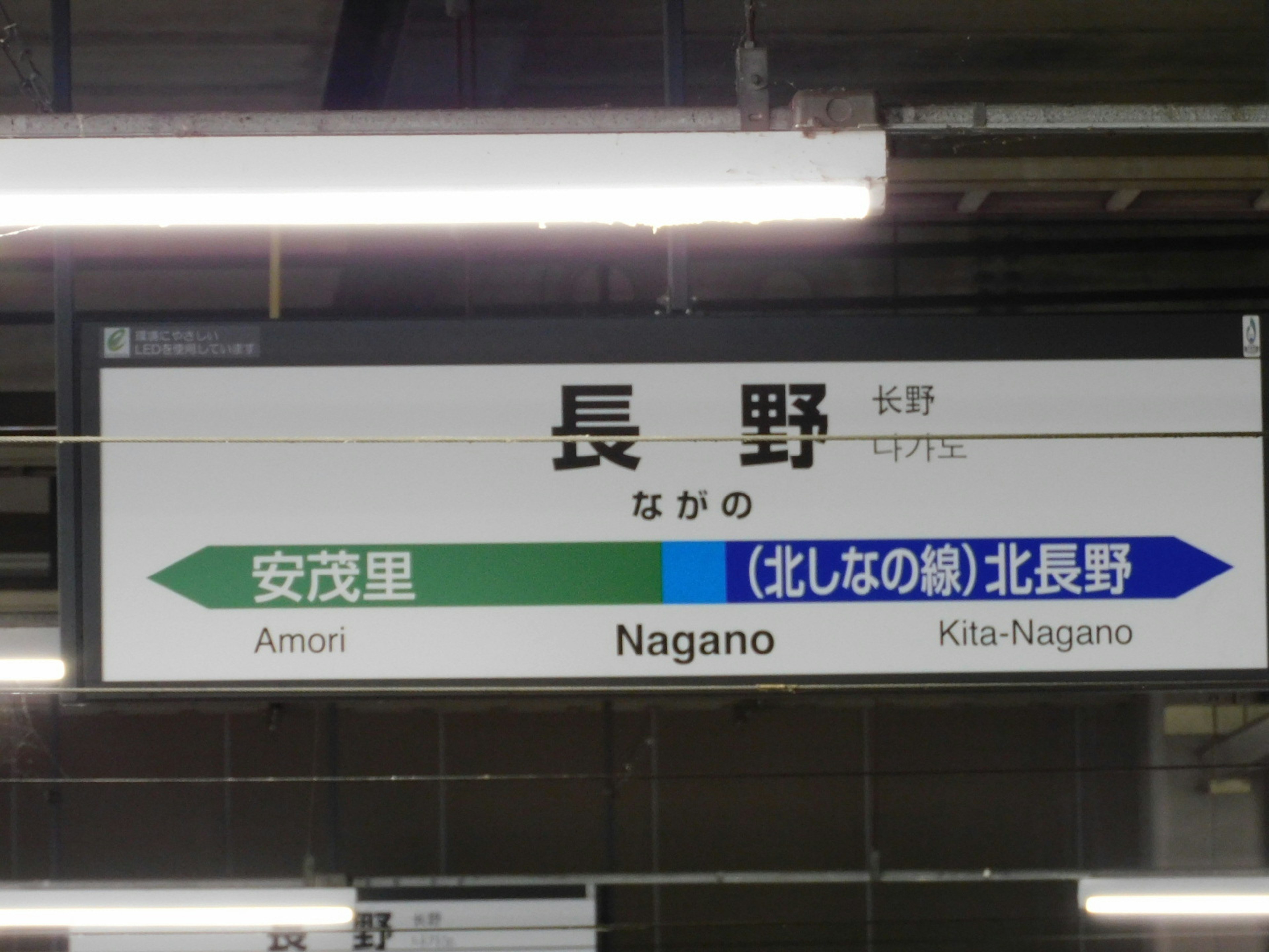 Cartel de la estación de Nagano mostrando direcciones a Azumino y Kita-Nagano