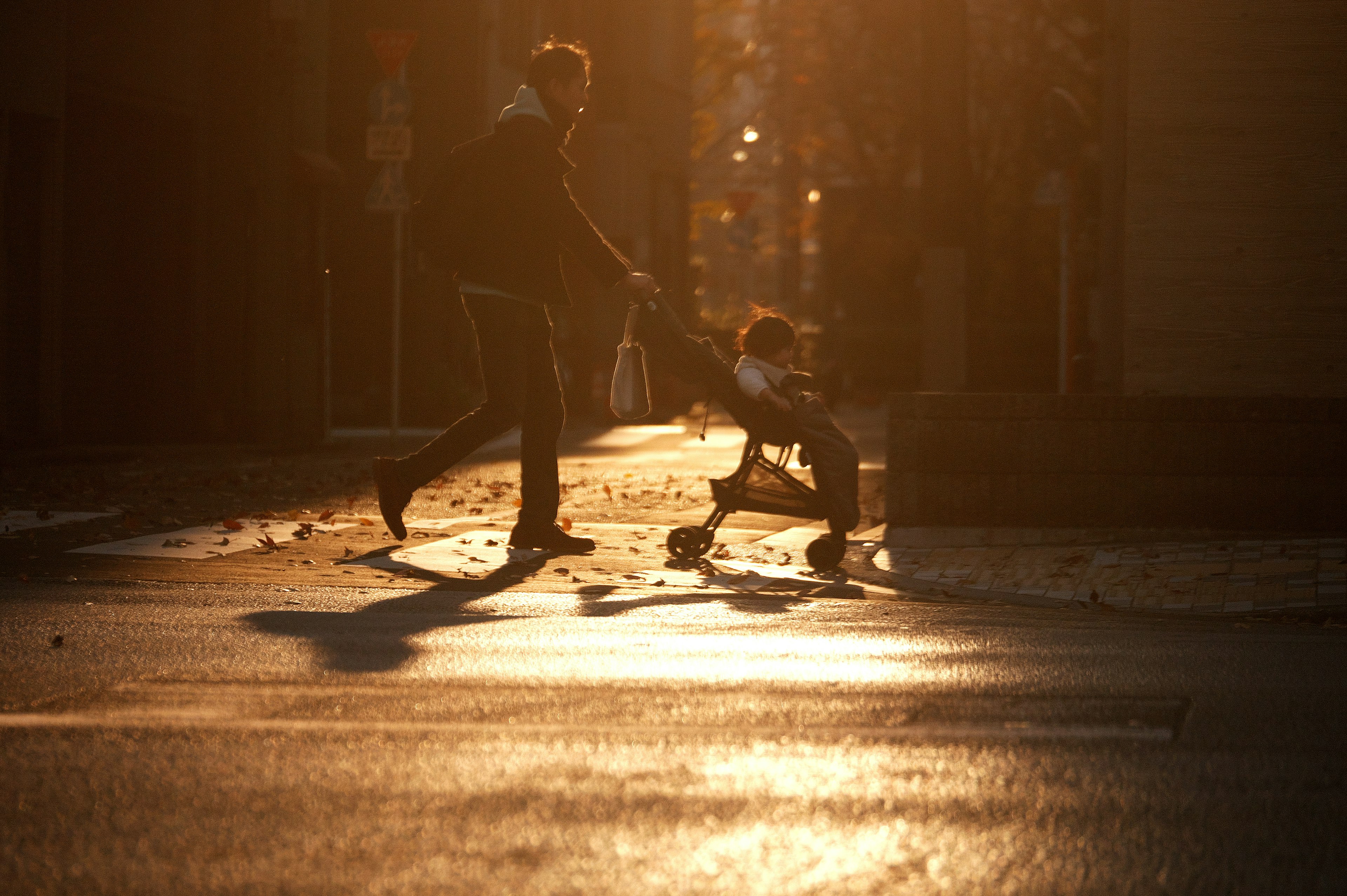 Silhouette d'un adulte tirant un enfant au coucher du soleil