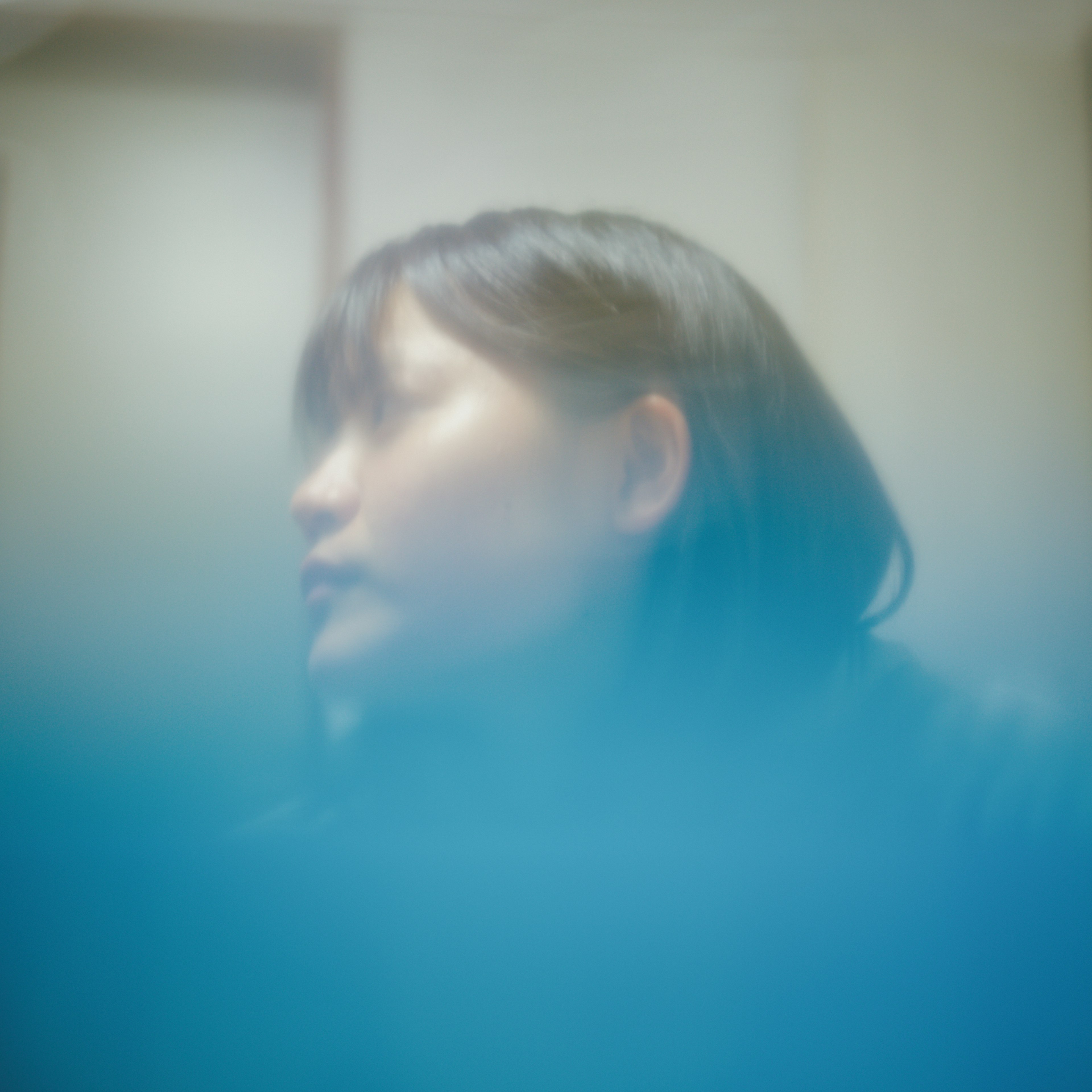 A woman looking sideways with a blurred blue background