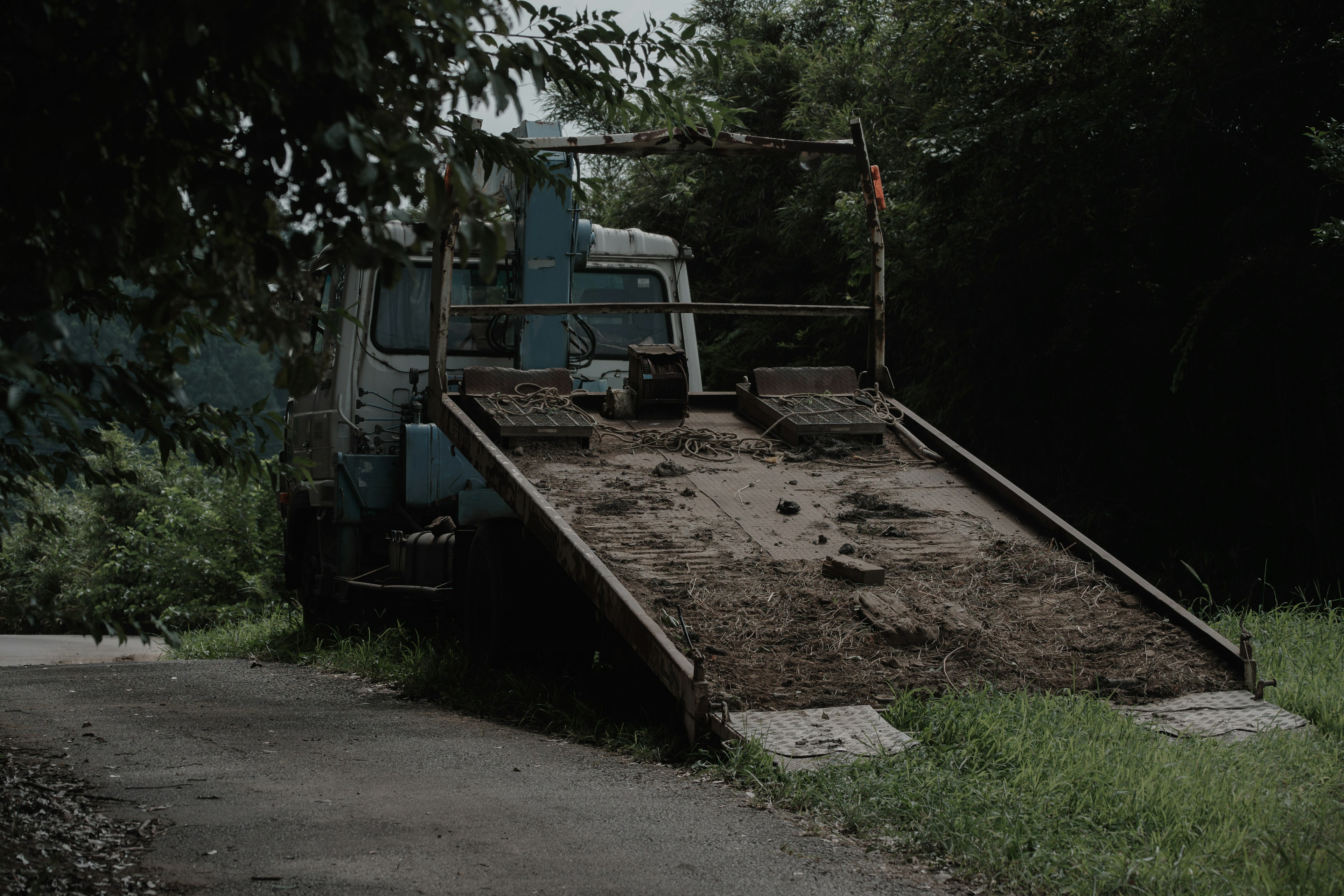 一輛裝滿泥土的廢棄卡車停在小路上