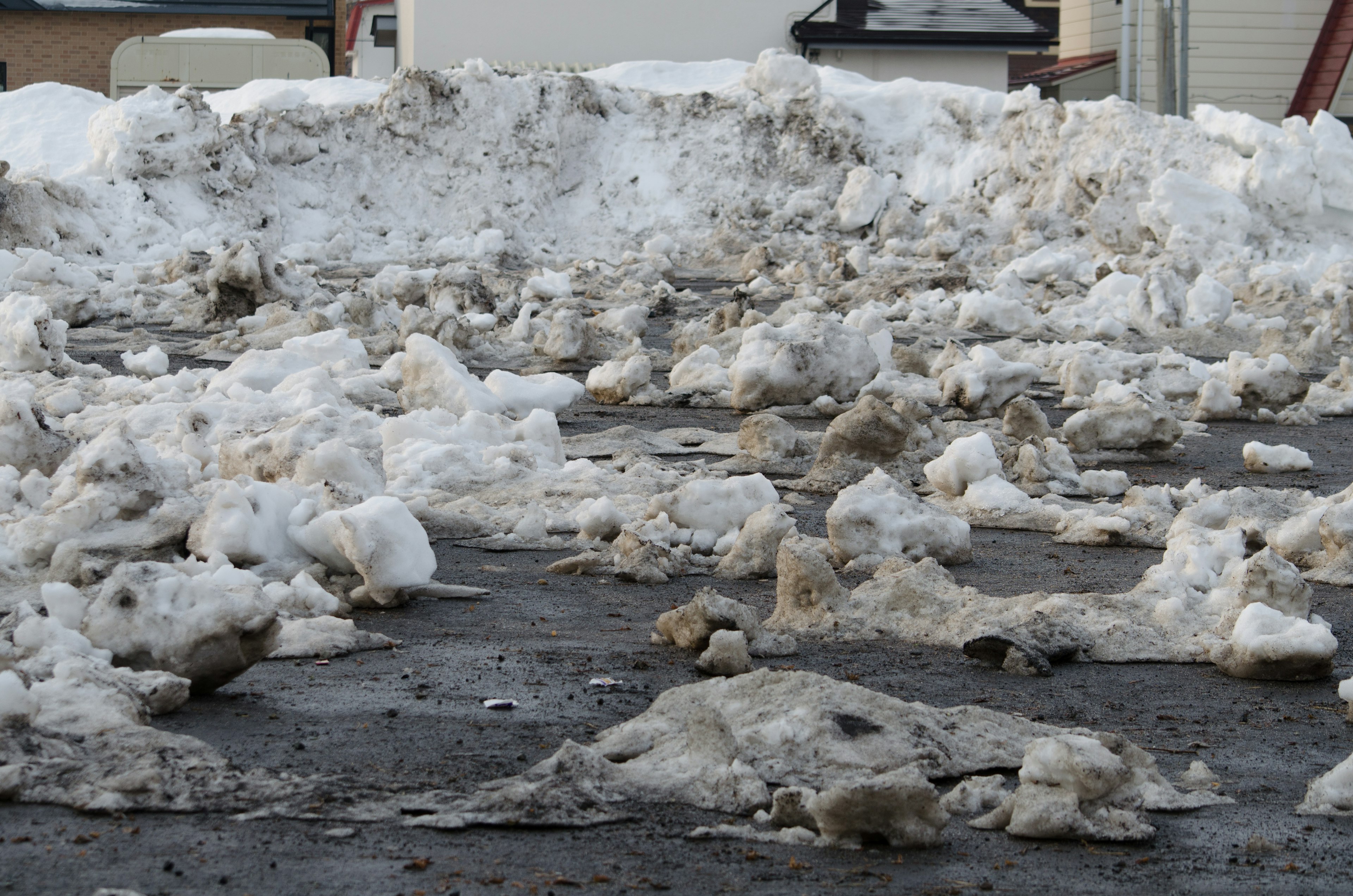 雪の塊と汚れた氷のある道路の風景