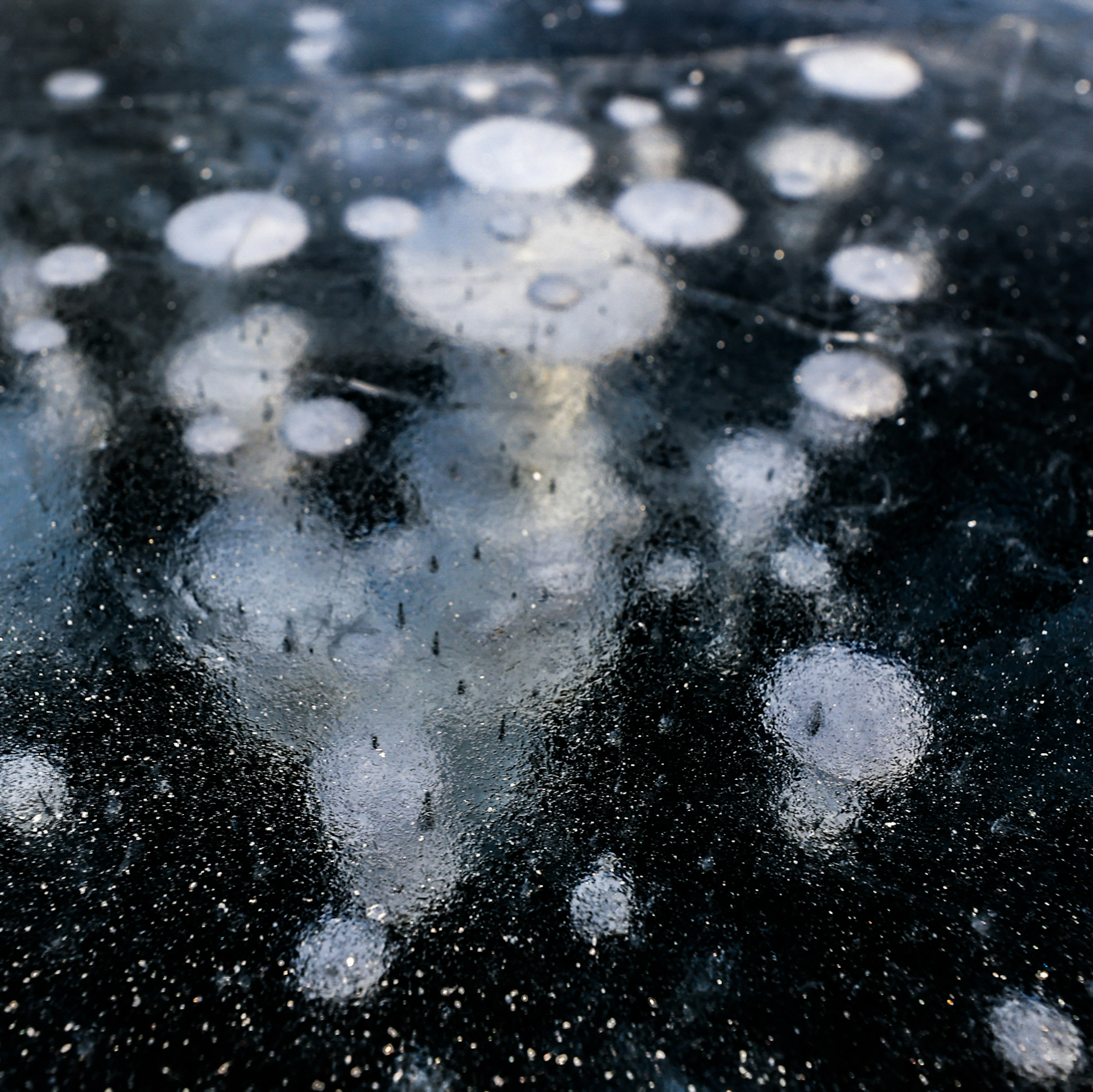 Bubbles and light reflections on an ice surface