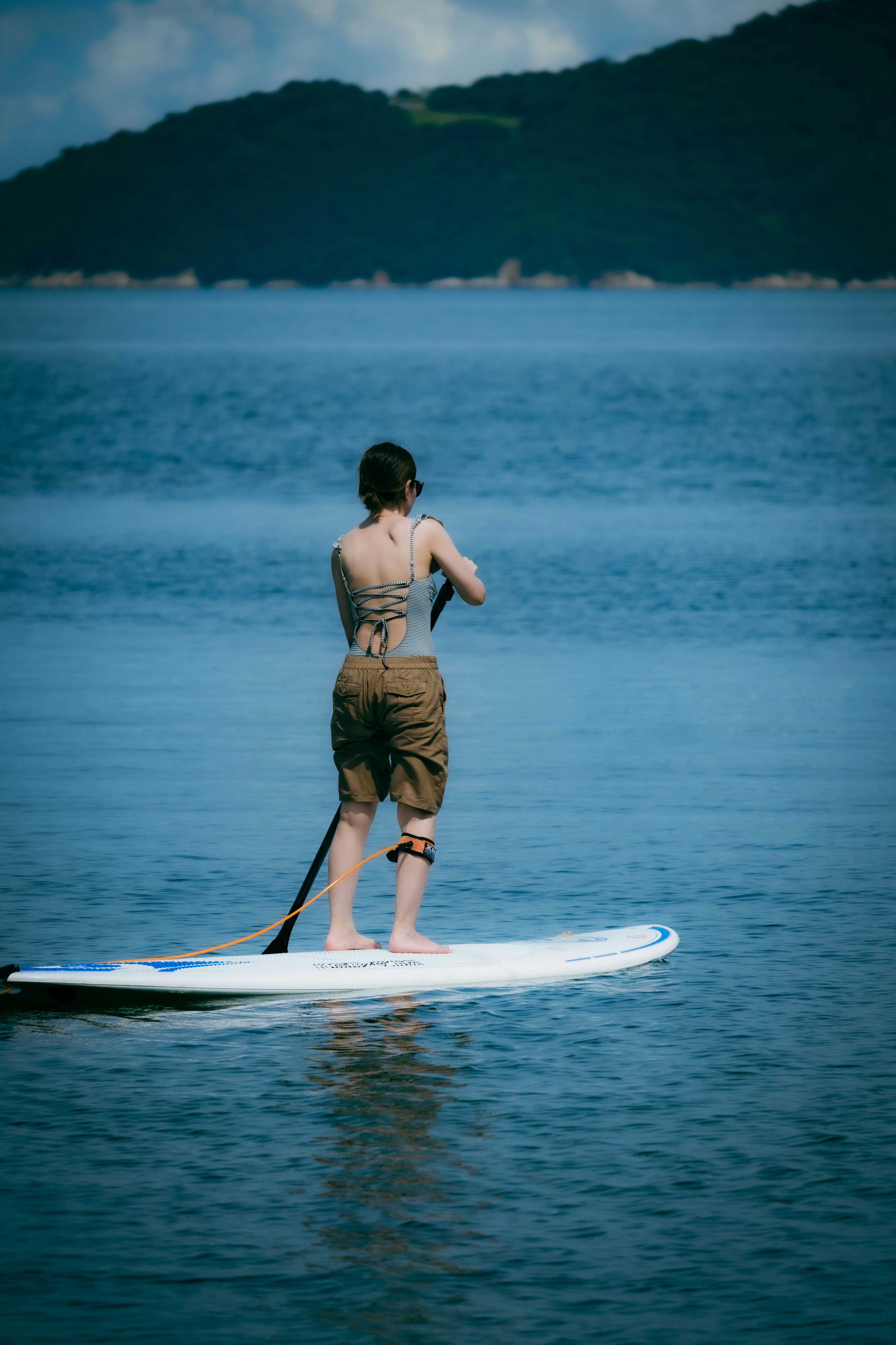 Personne pagayant sur une planche de paddle dans des eaux calmes