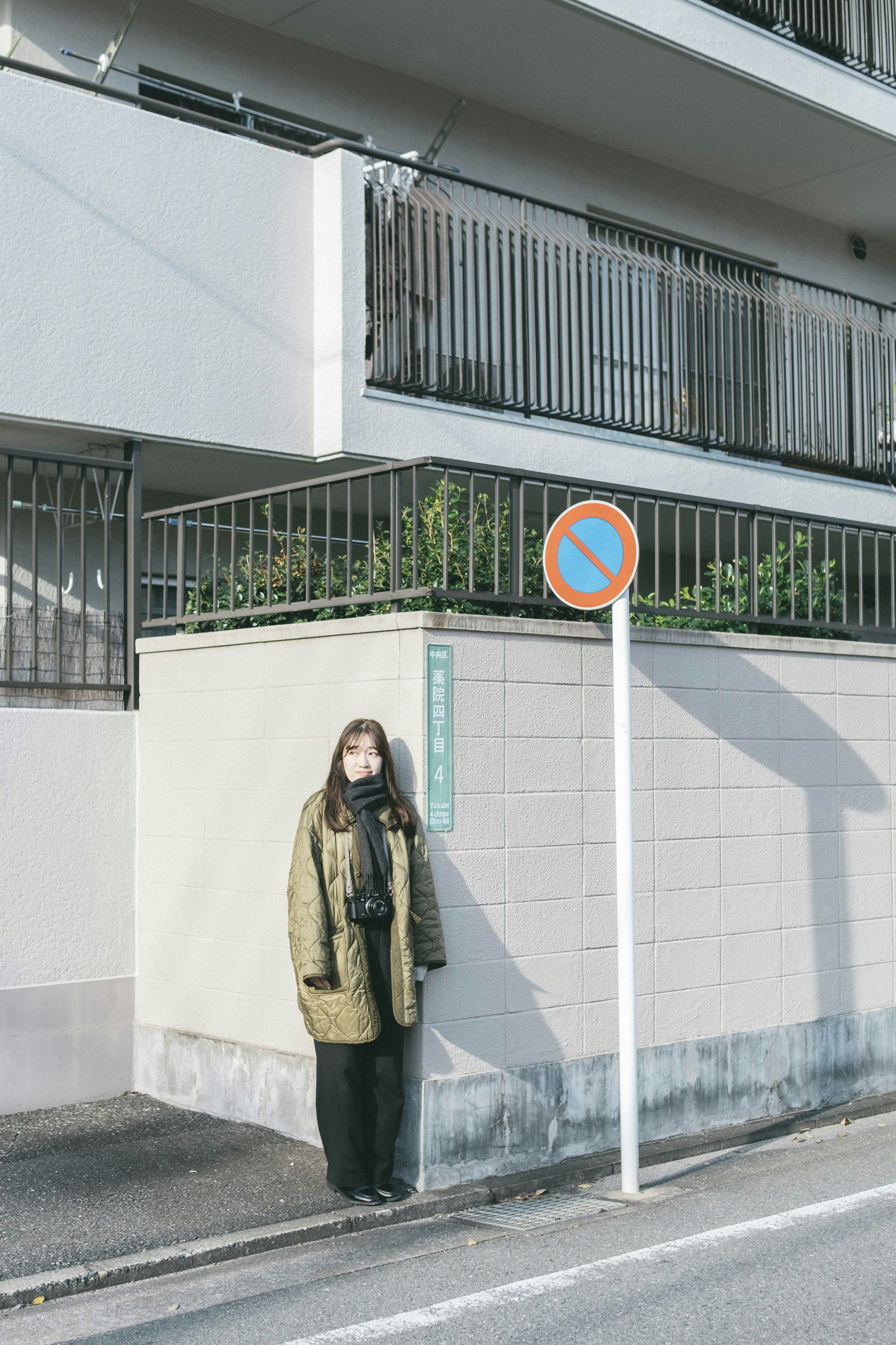 街角に立つ女性と建物の外観