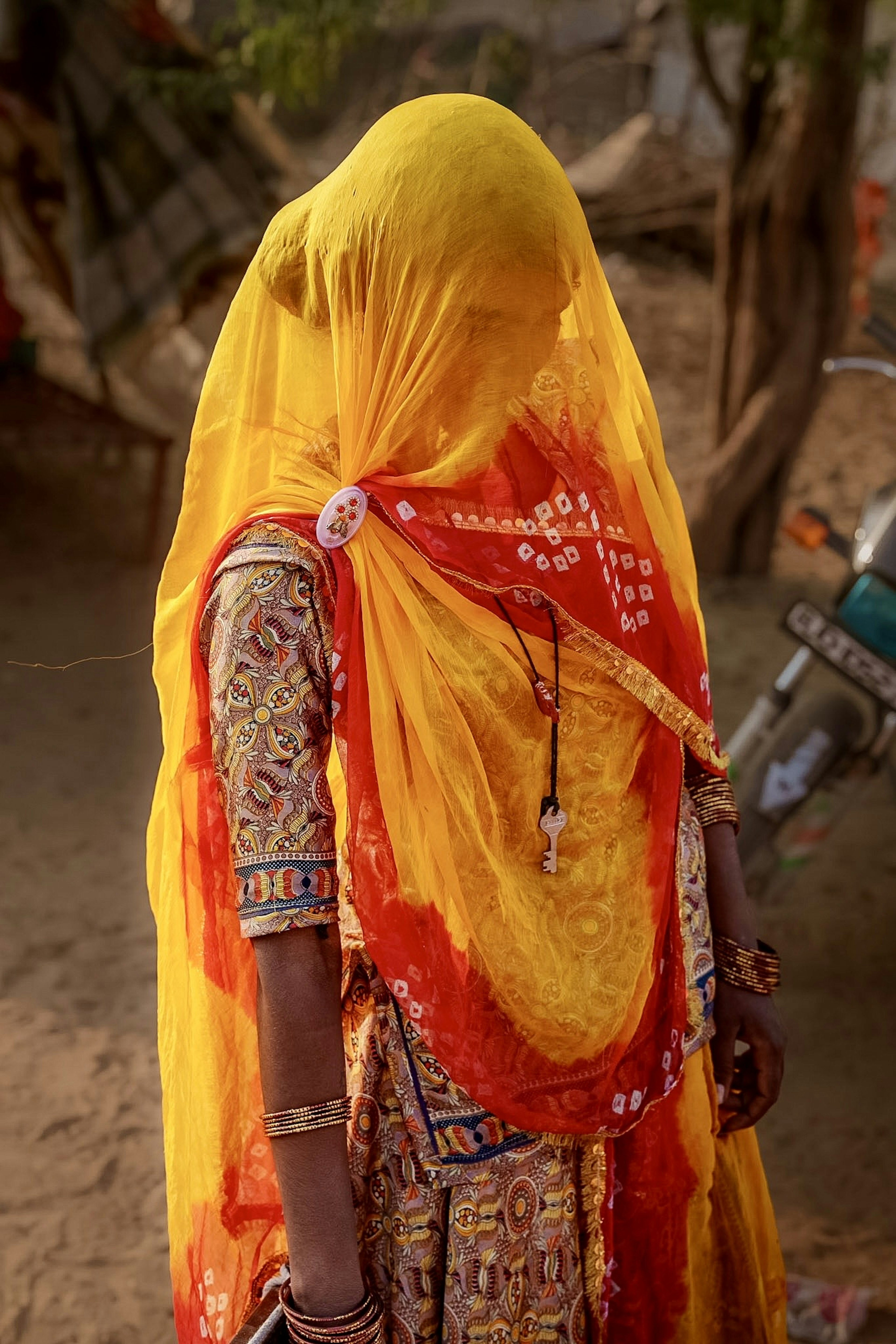 A woman wearing a yellow veil and red attire