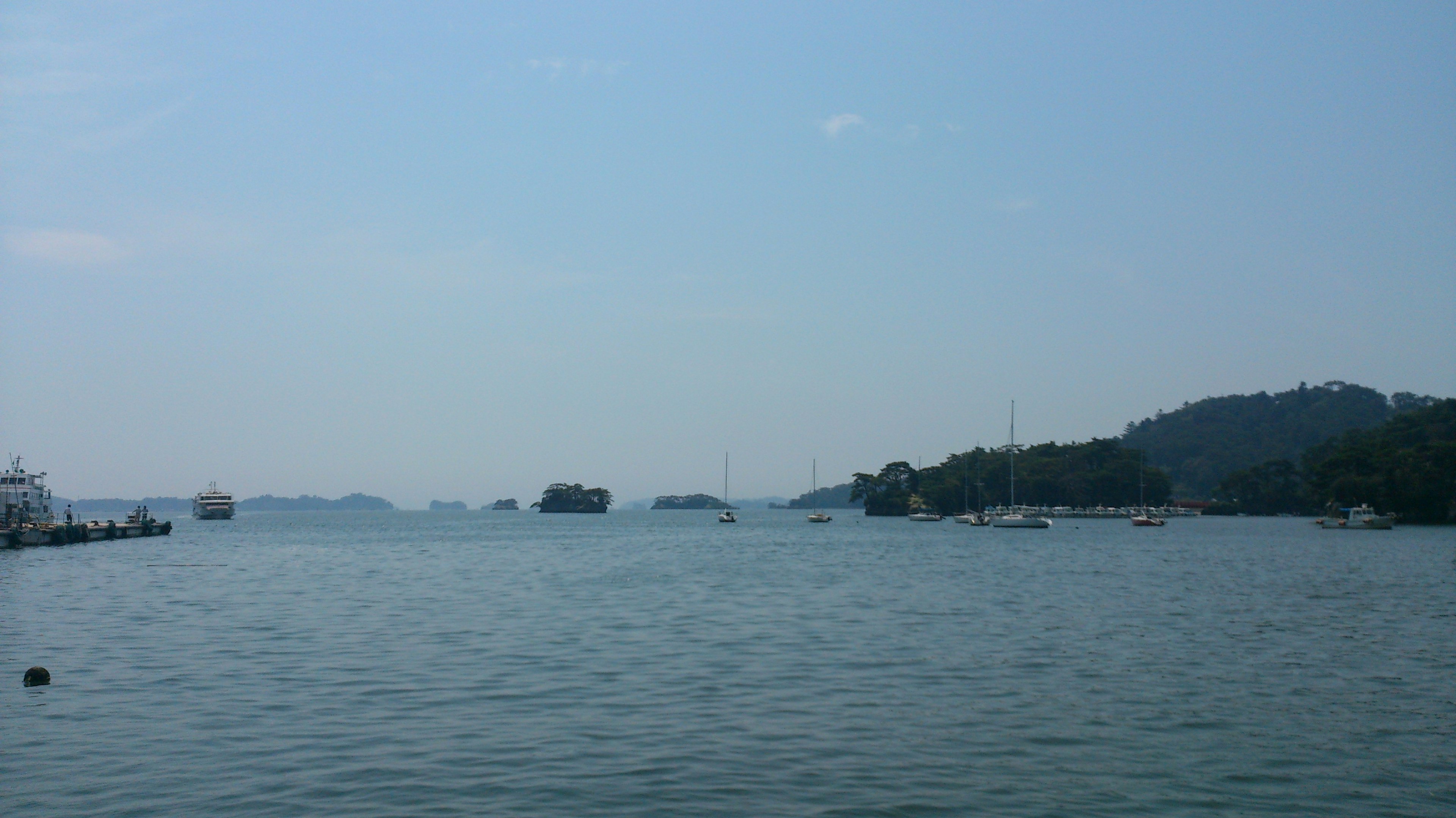 Ruhige Meeresansicht mit blauem Himmel und fernen Hügeln