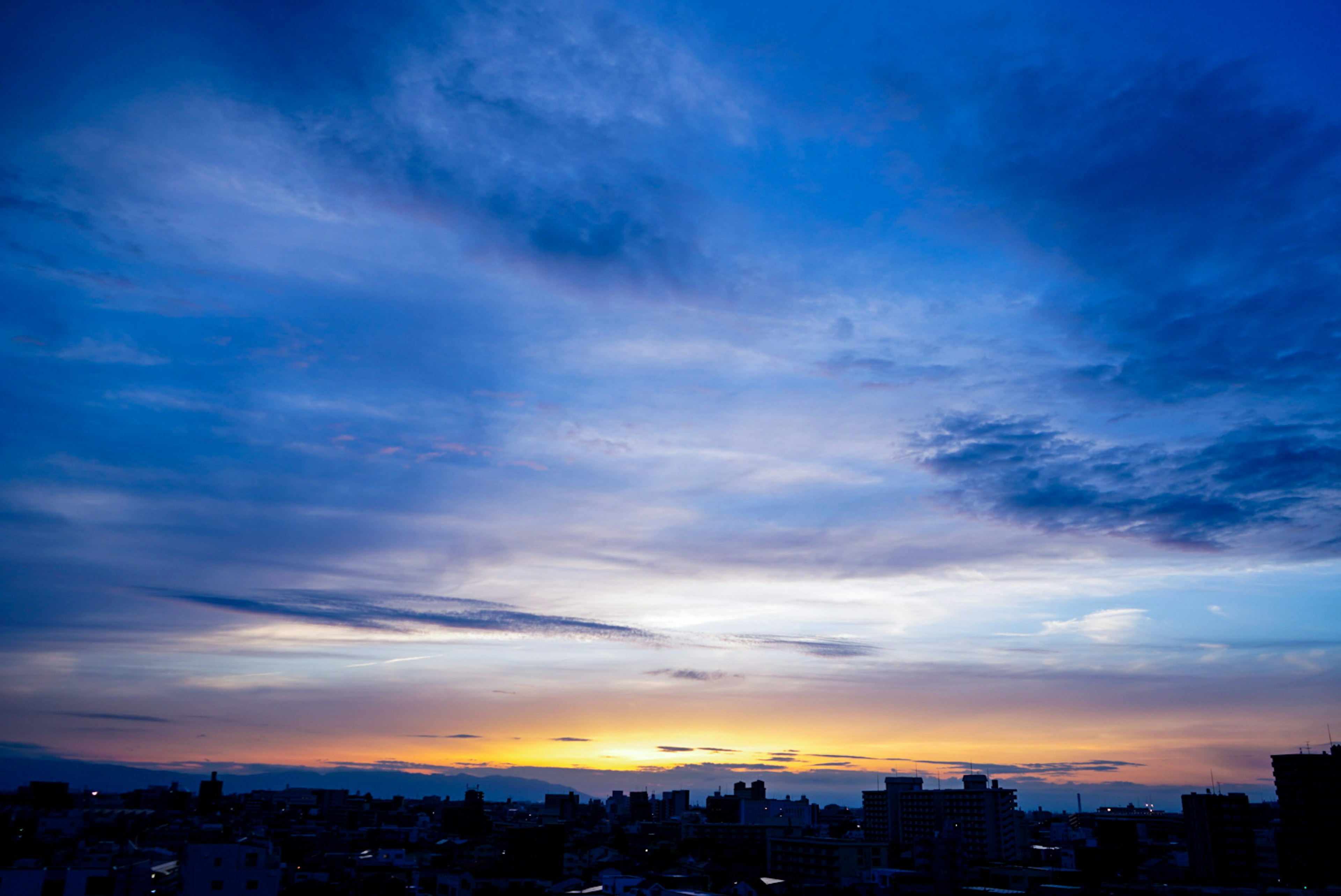 Stadtansicht bei Sonnenuntergang mit lebendigen Blau- und Orangetönen im Himmel