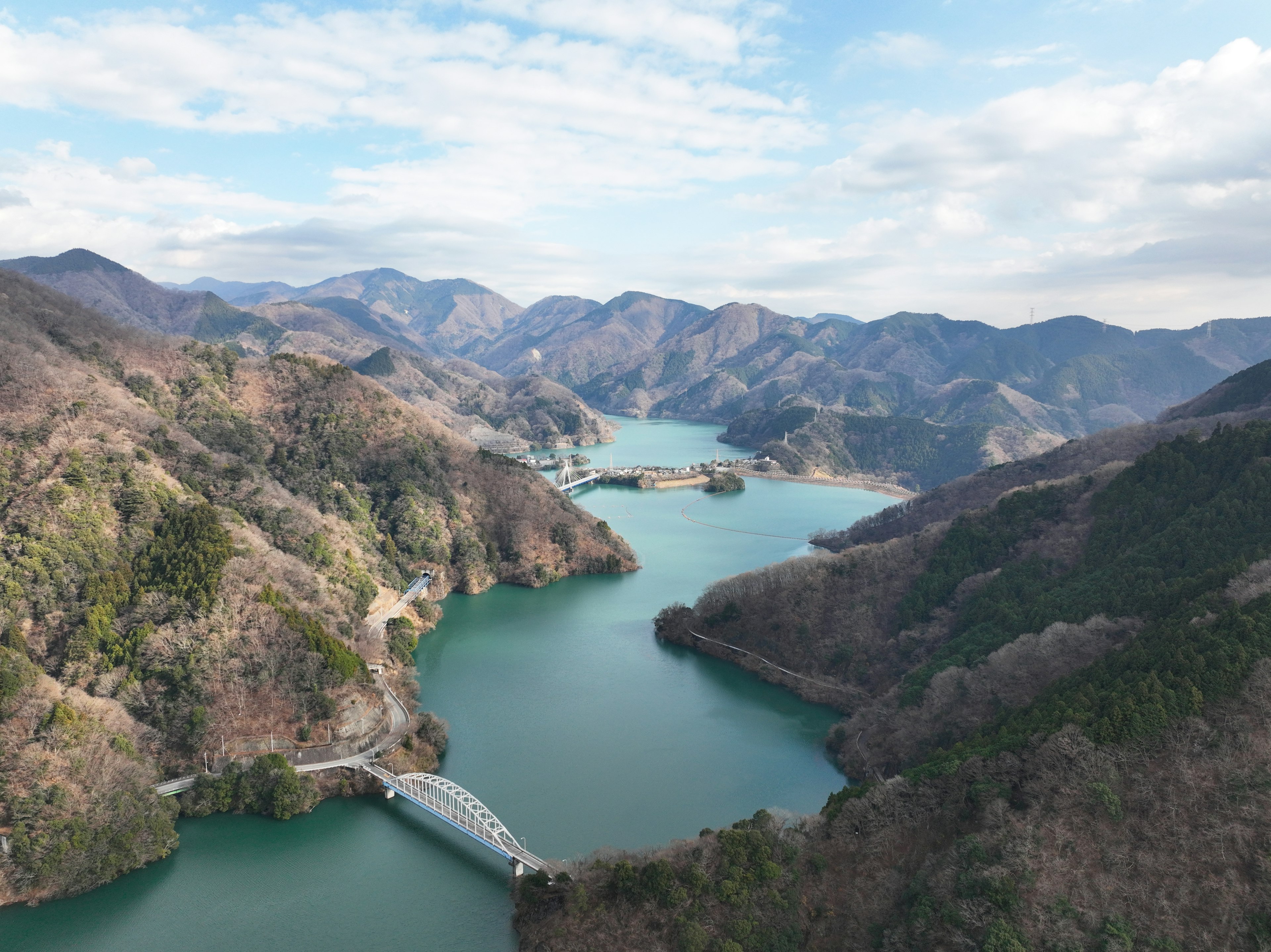 Vista panoramica di un lago circondato da montagne con un ponte