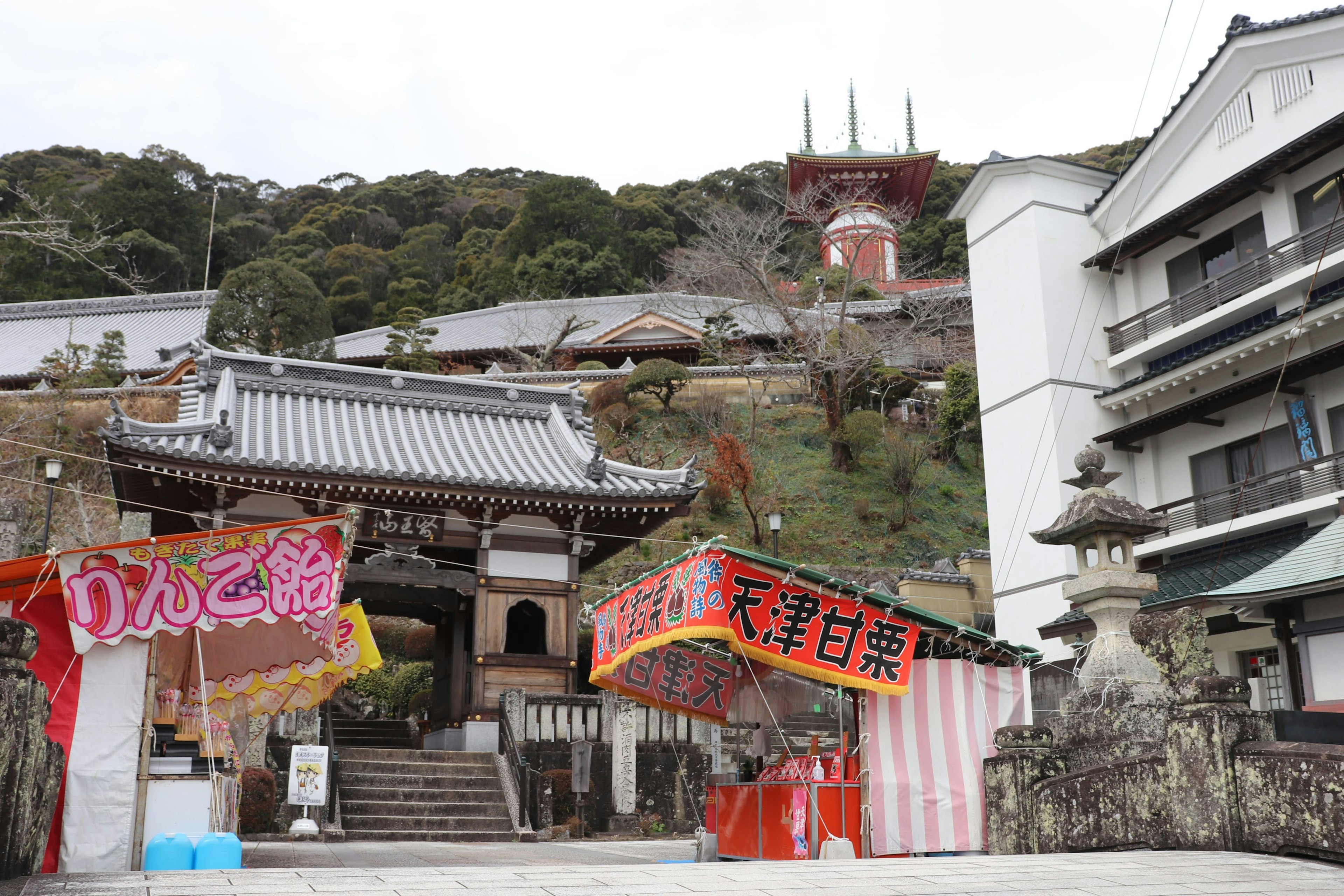 View of a temple located on a hill with surrounding buildings and festival decorations at the entrance