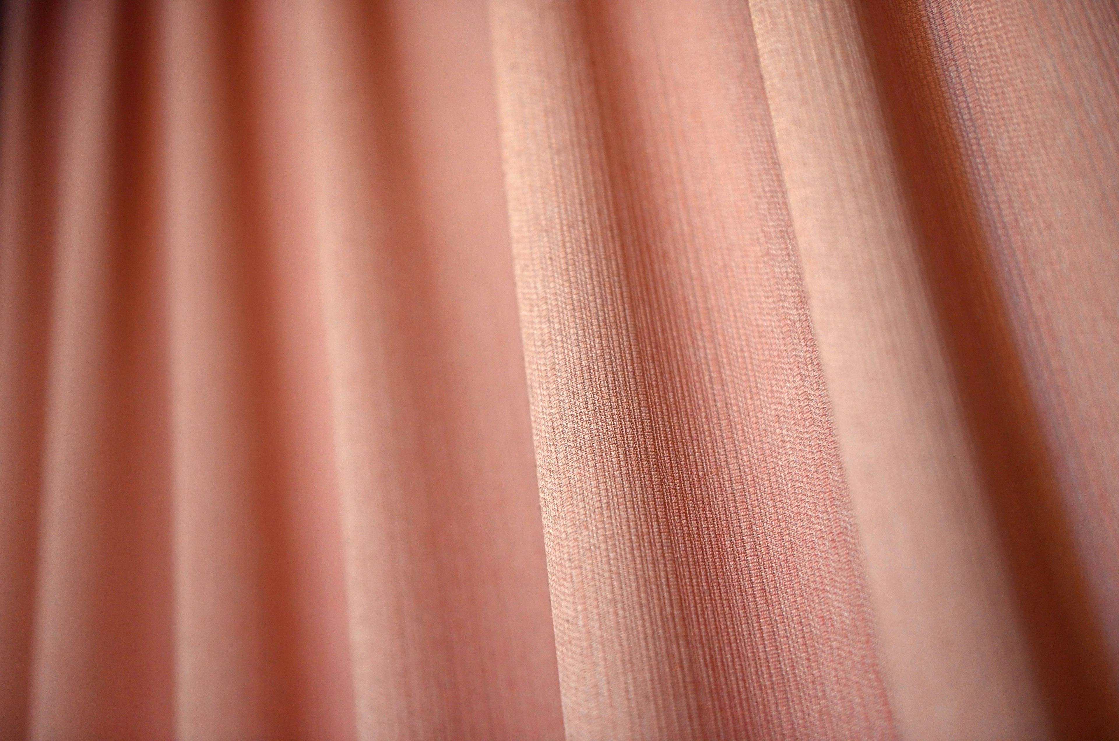 Close-up of textured pink curtain fabric with pleats