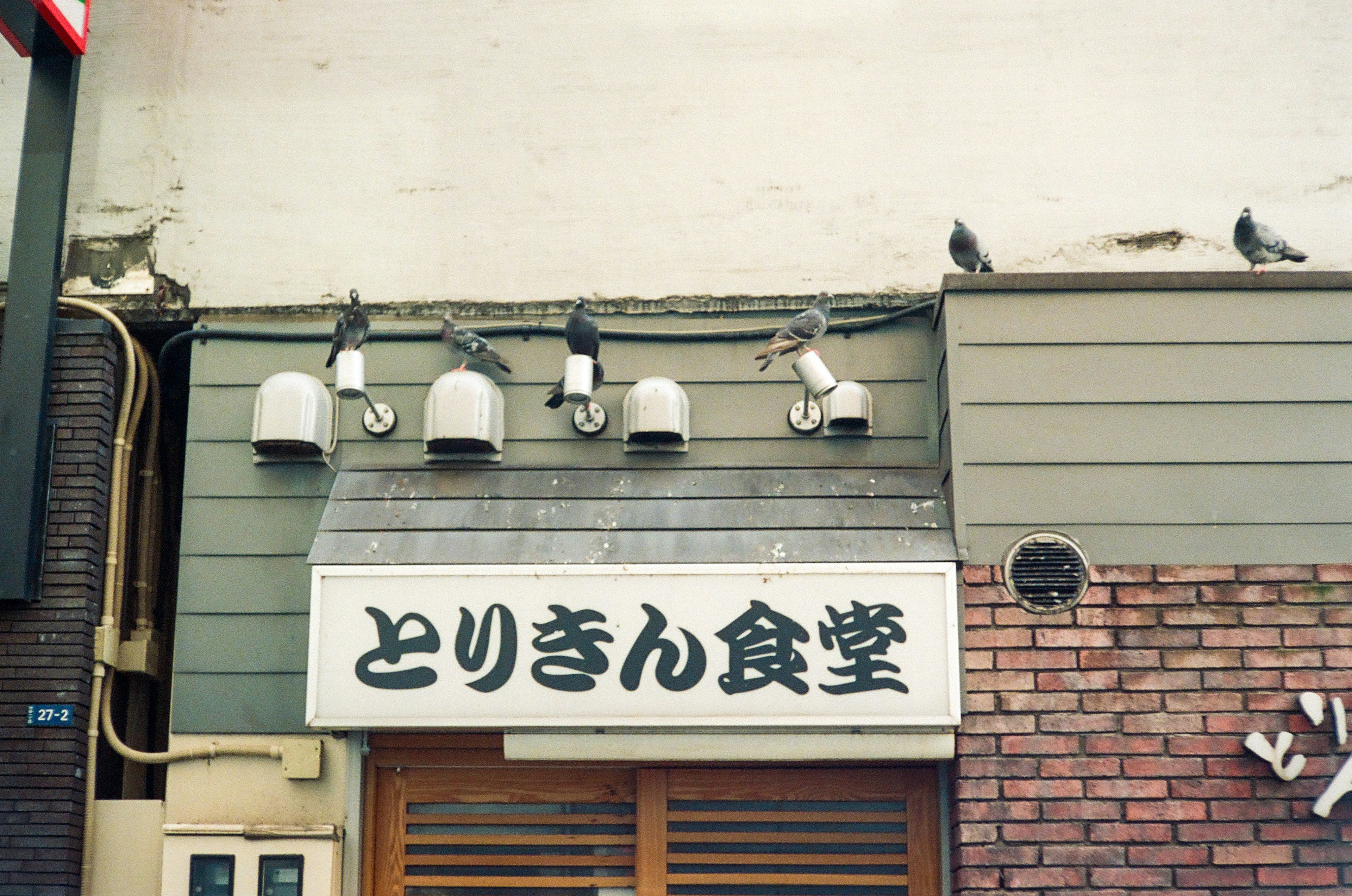 とりきん食堂の看板と照明器具がある外観