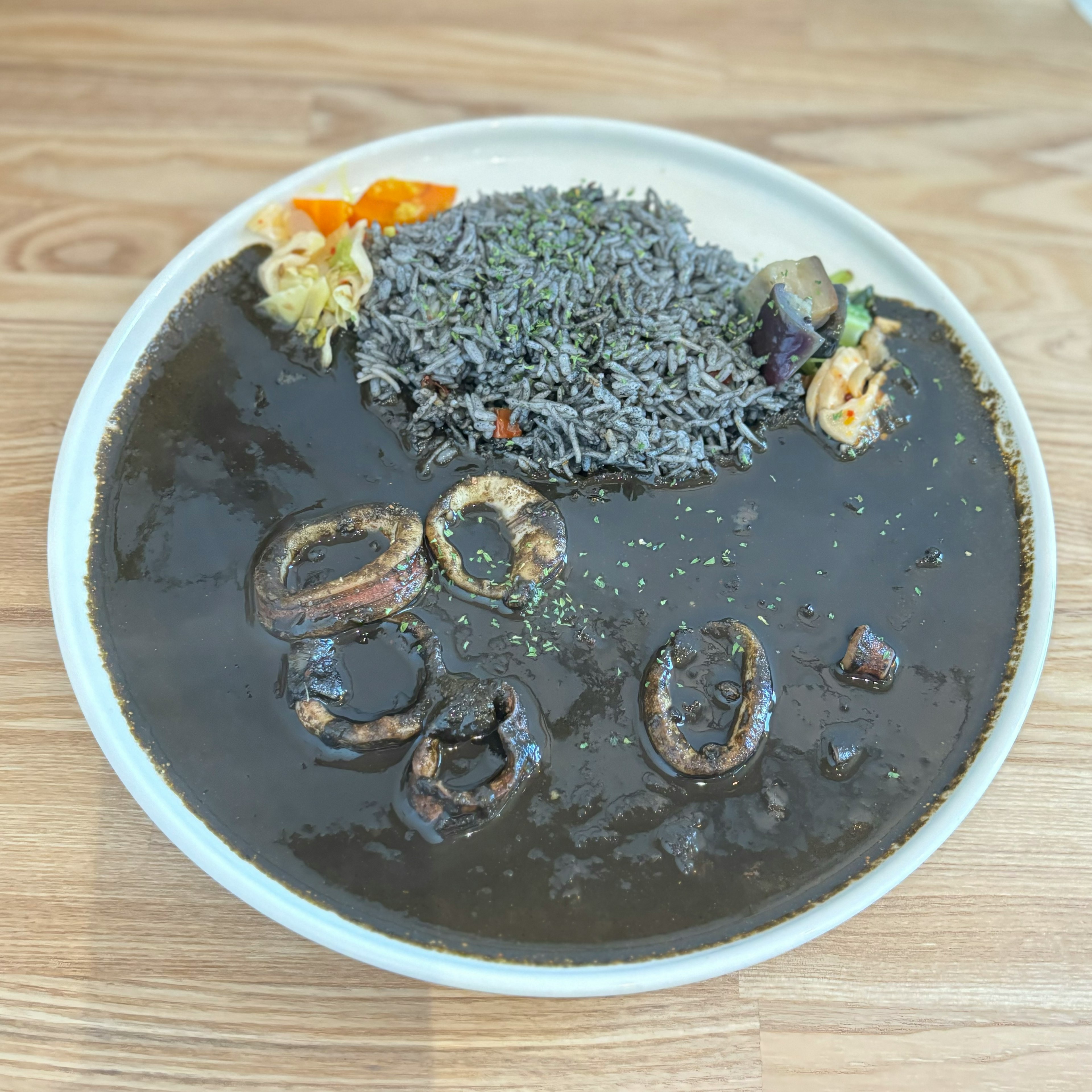 Plat avec une soupe noire, du riz et des légumes