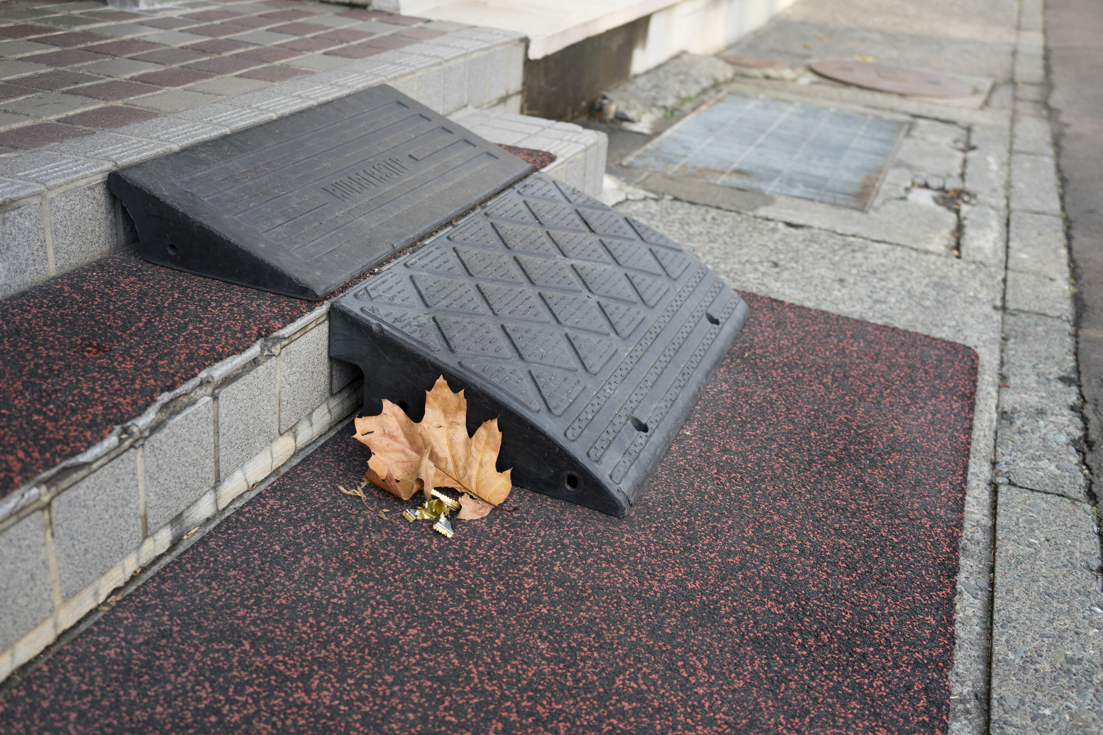 Black ramp positioned before steps with fallen leaves