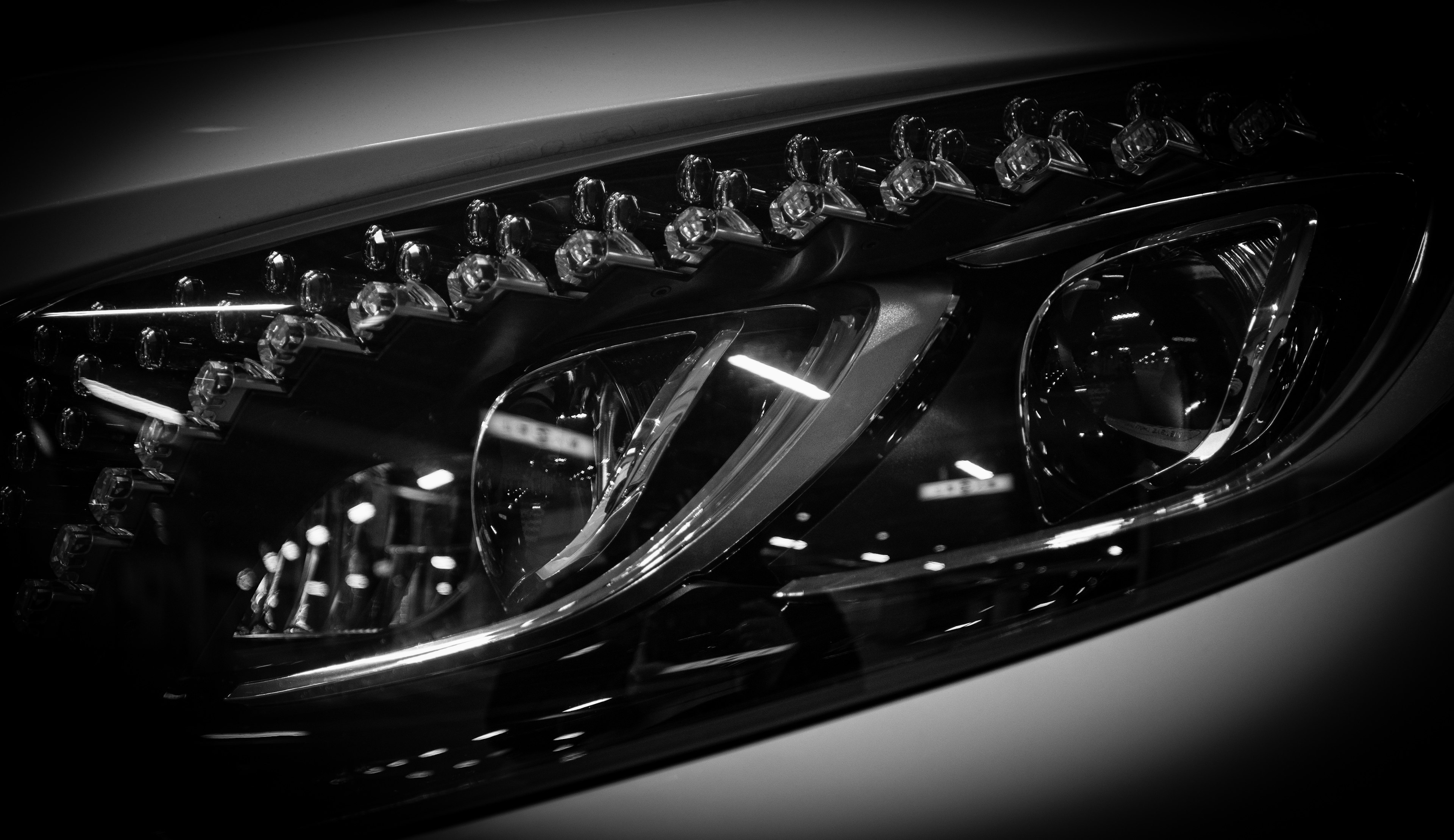 Close-up of a car headlight featuring a sleek black and silver design