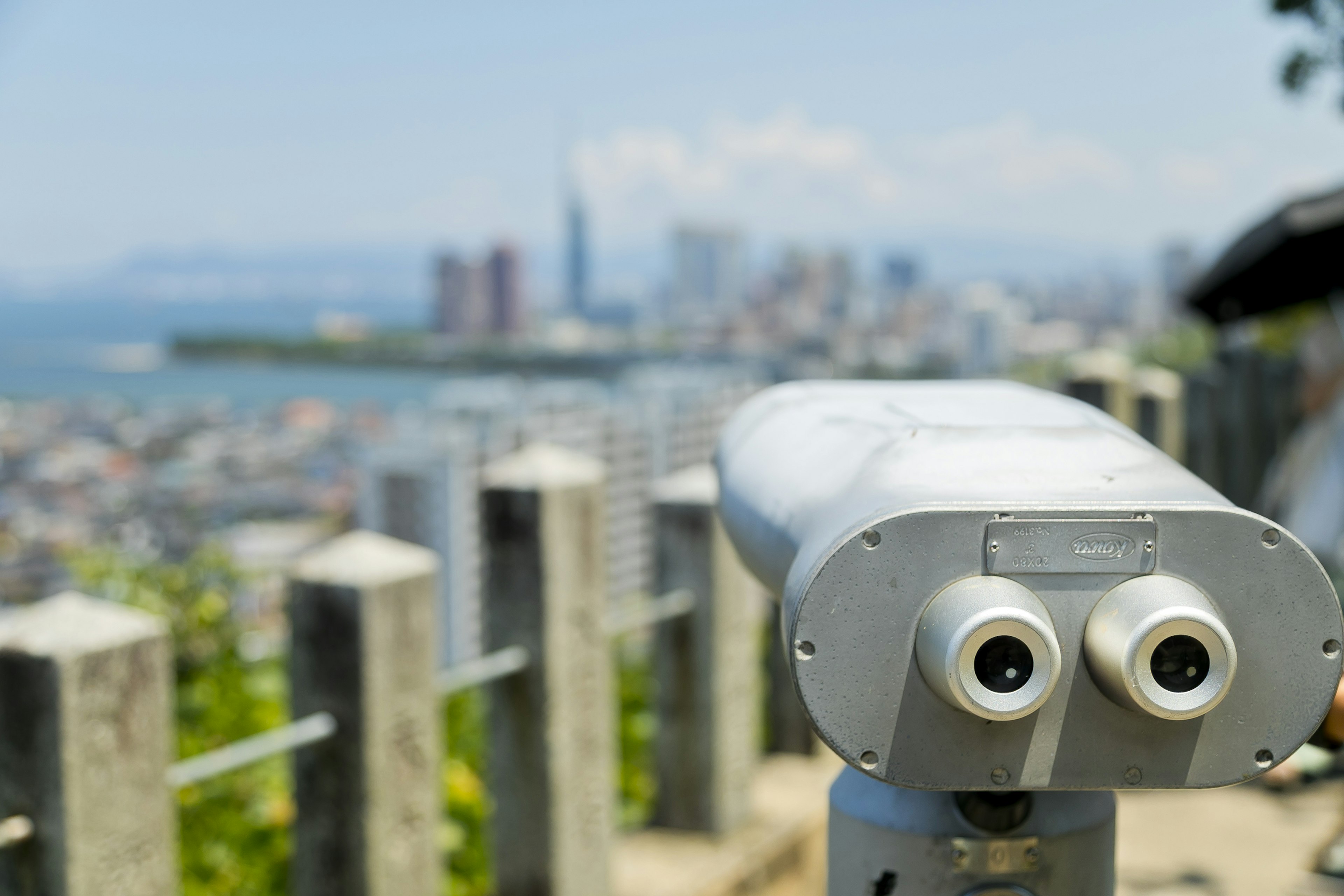 Viewpoint binoculars overlooking a city skyline