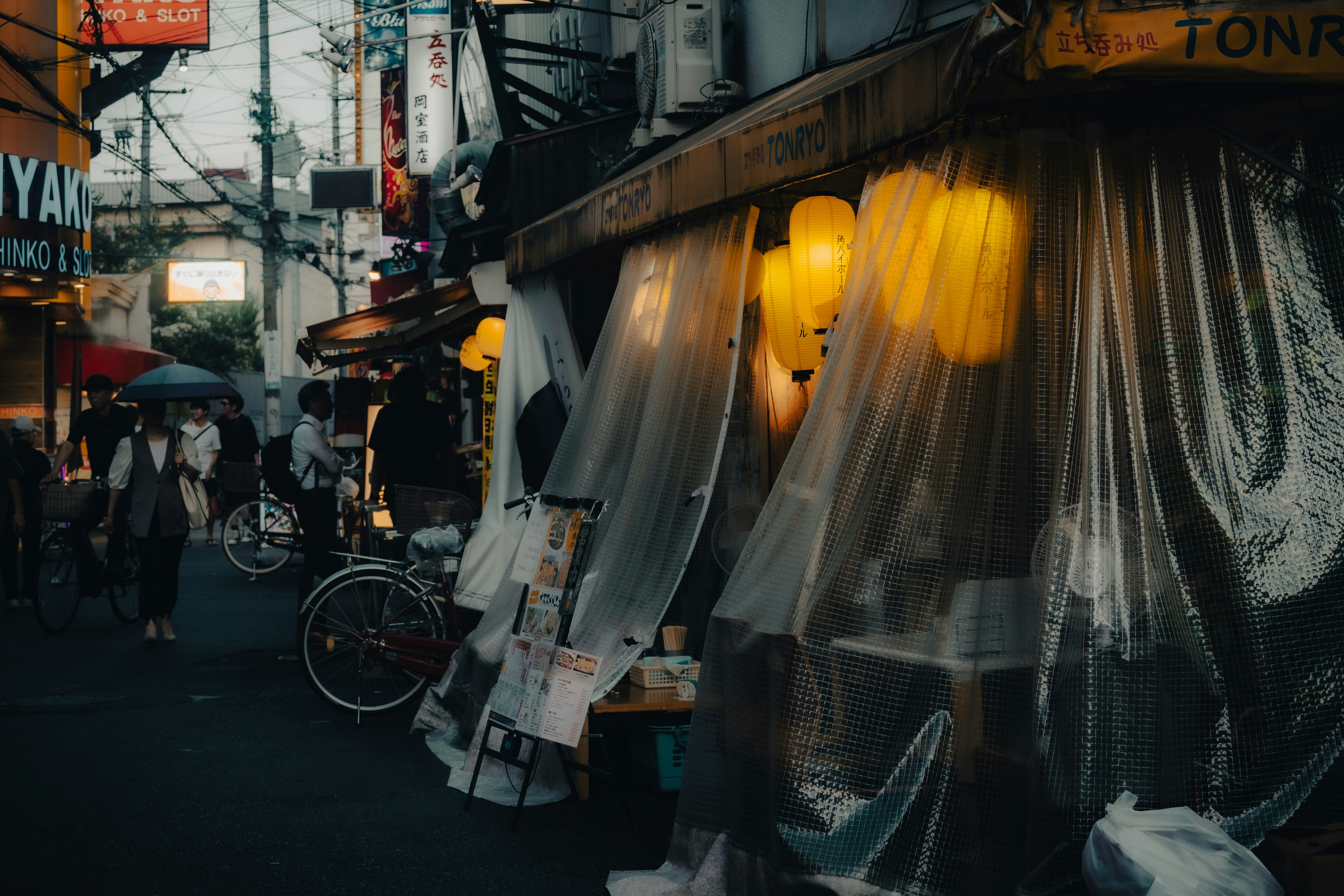 Escena de calle débilmente iluminada con puestos y faroles