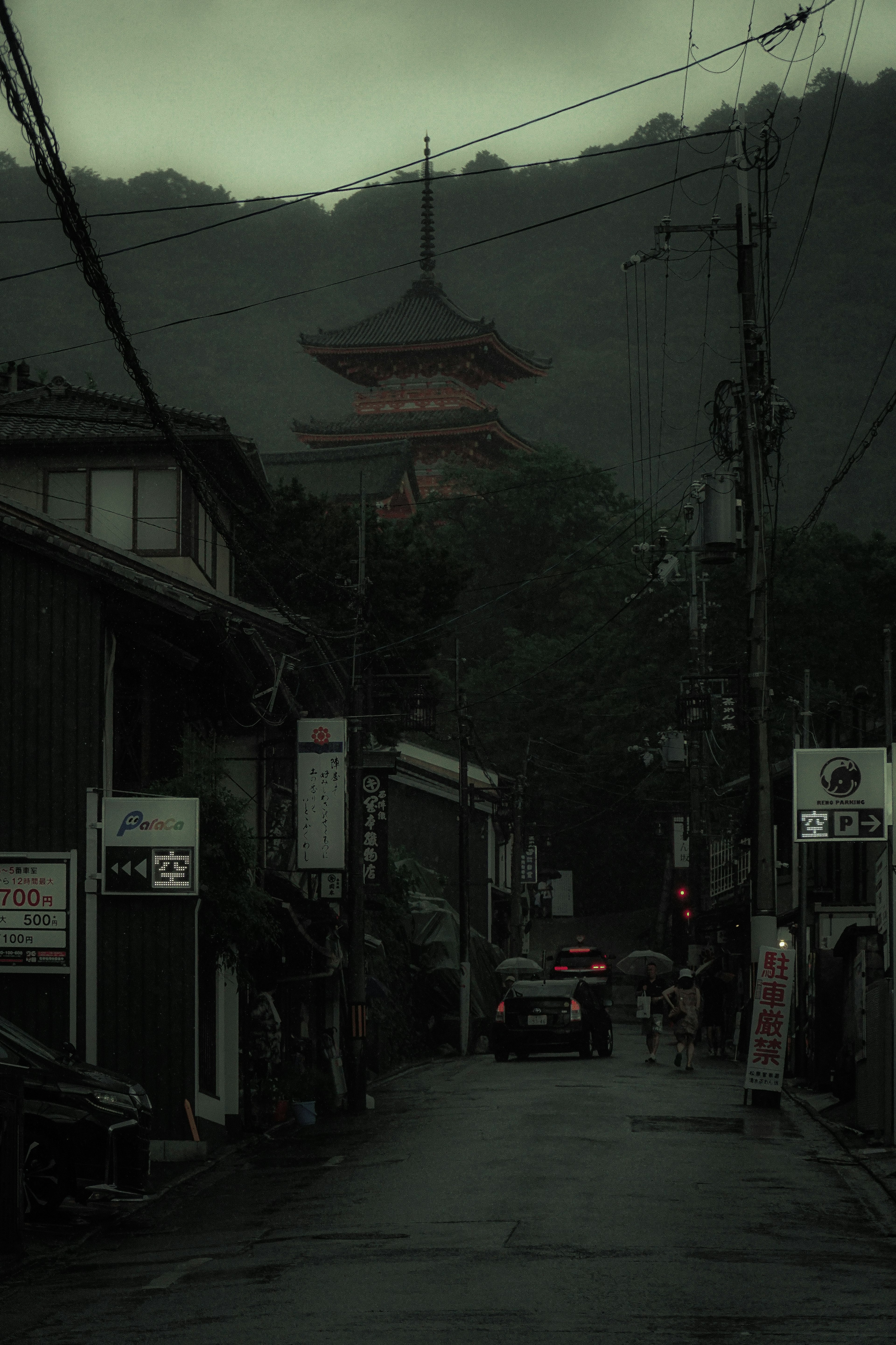 Pemandangan jalan yang diselimuti kabut dengan pagoda merah di latar belakang