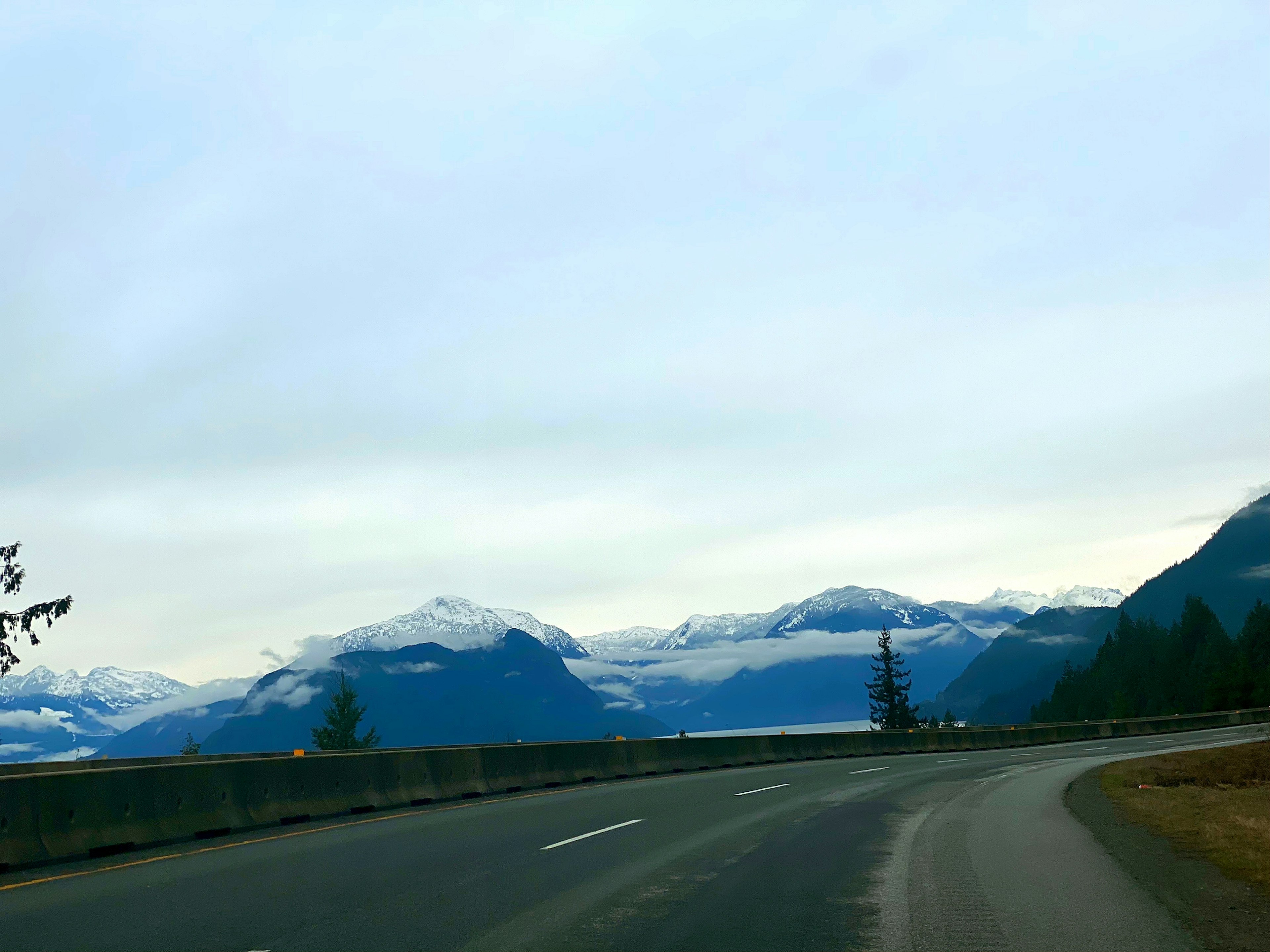 Vista panoramica di montagne innevate lungo una strada tortuosa