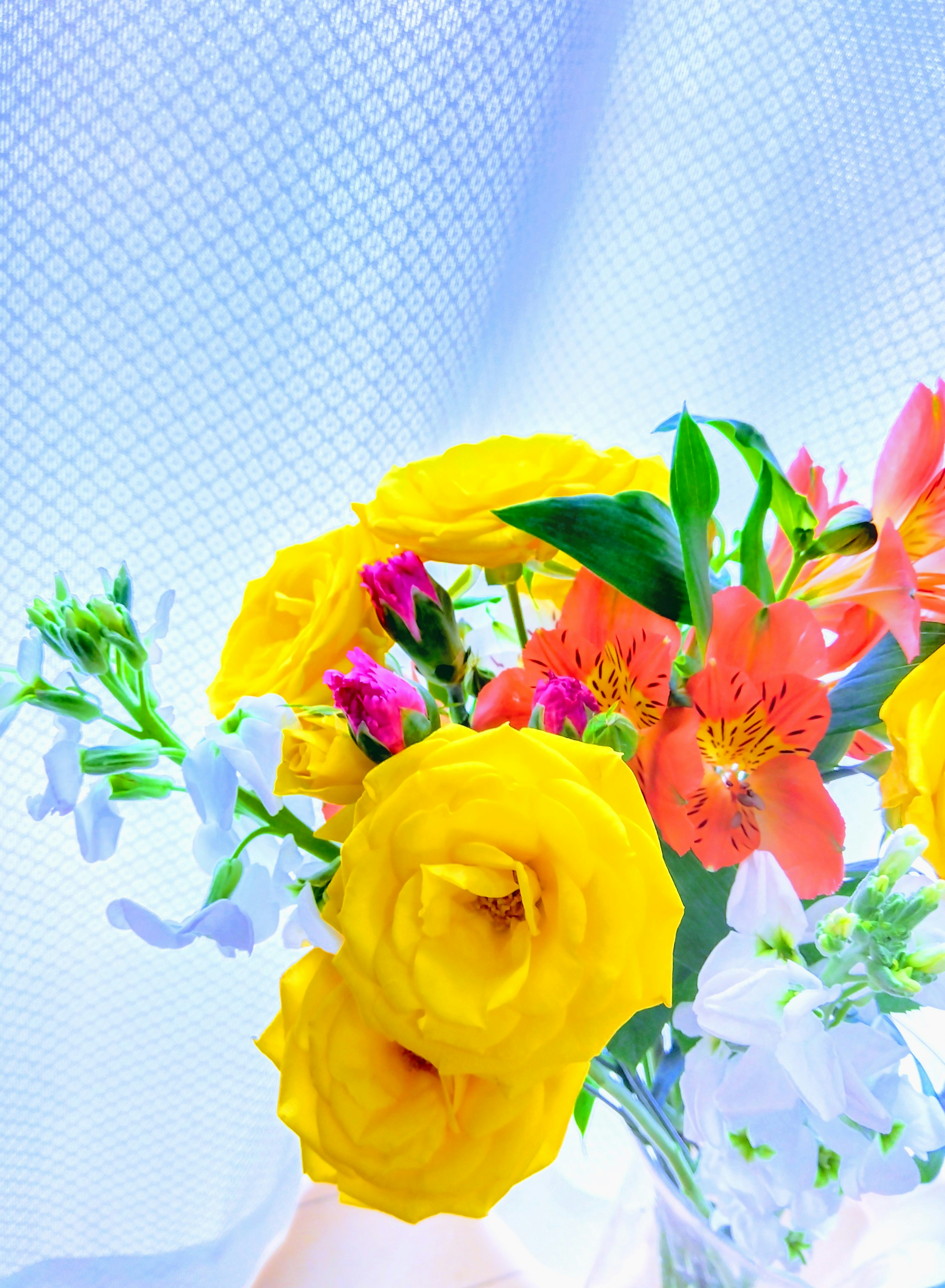 A bouquet of bright yellow roses and colorful flowers