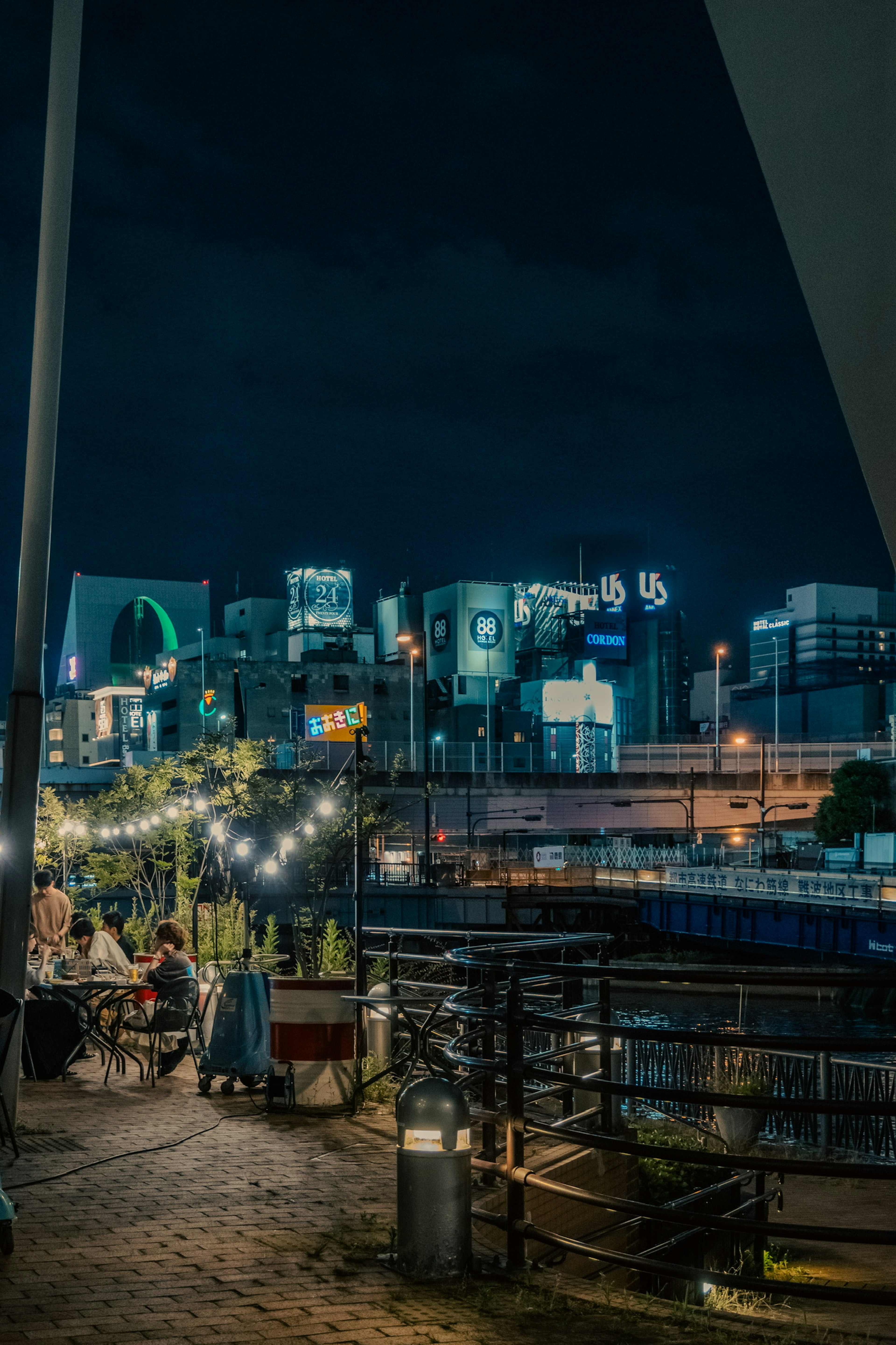 Nighttime cityscape featuring illuminated restaurant terrace