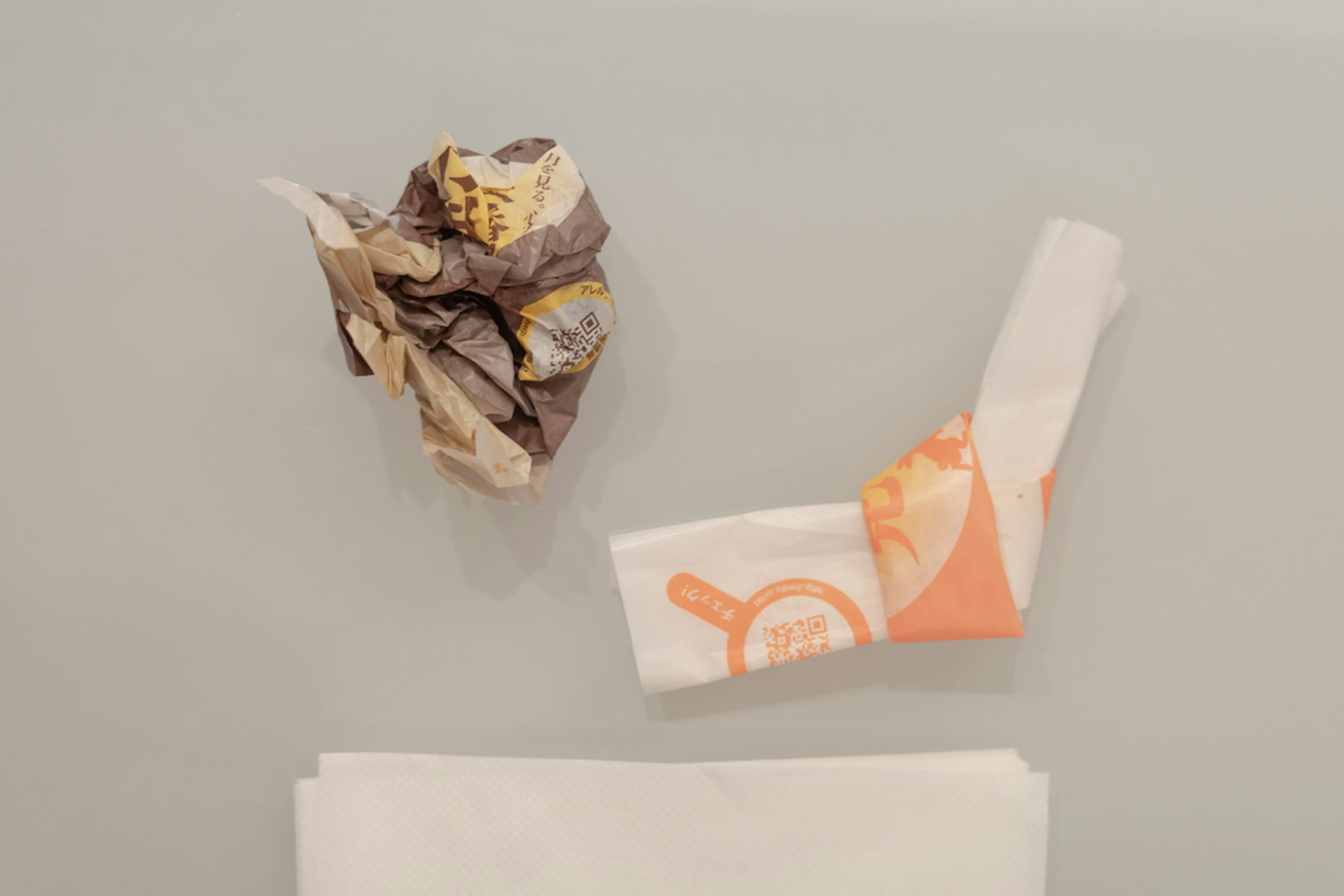 Crumpled wrapping paper and orange patterned wrapper on a white background