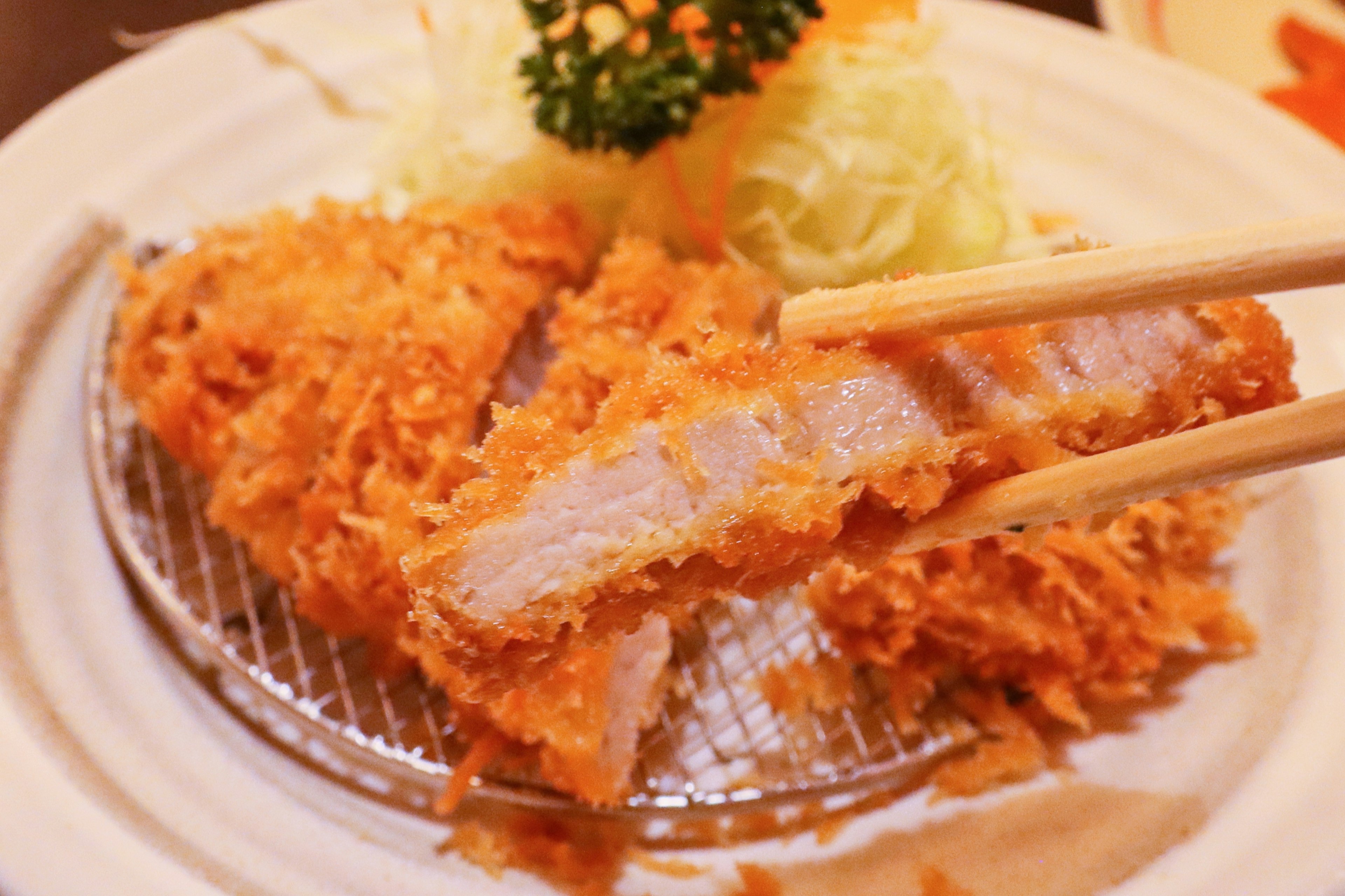 Plate of tonkatsu with shredded cabbage and garnish