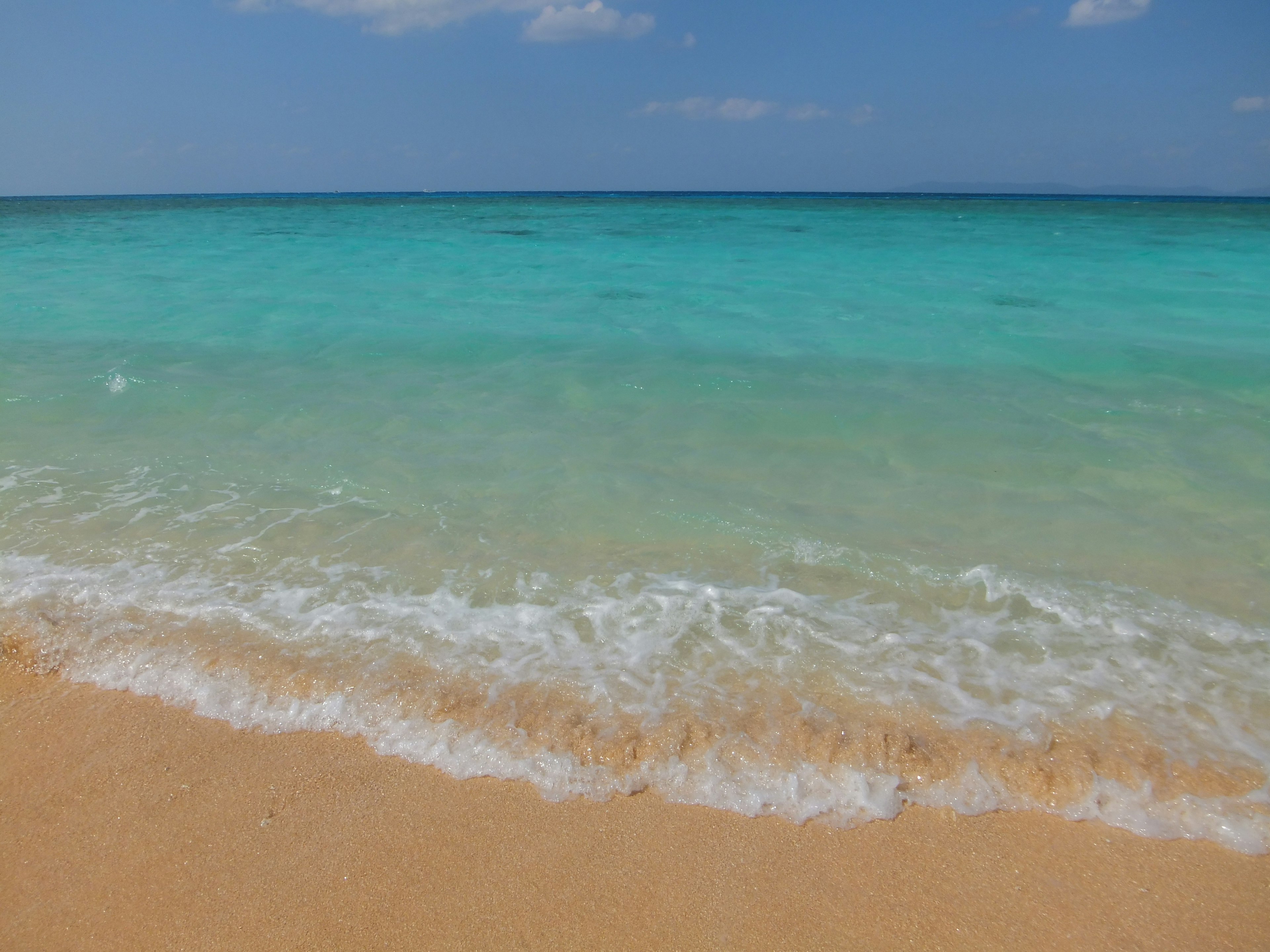 Scenic view of blue ocean and sandy beach gentle waves lapping