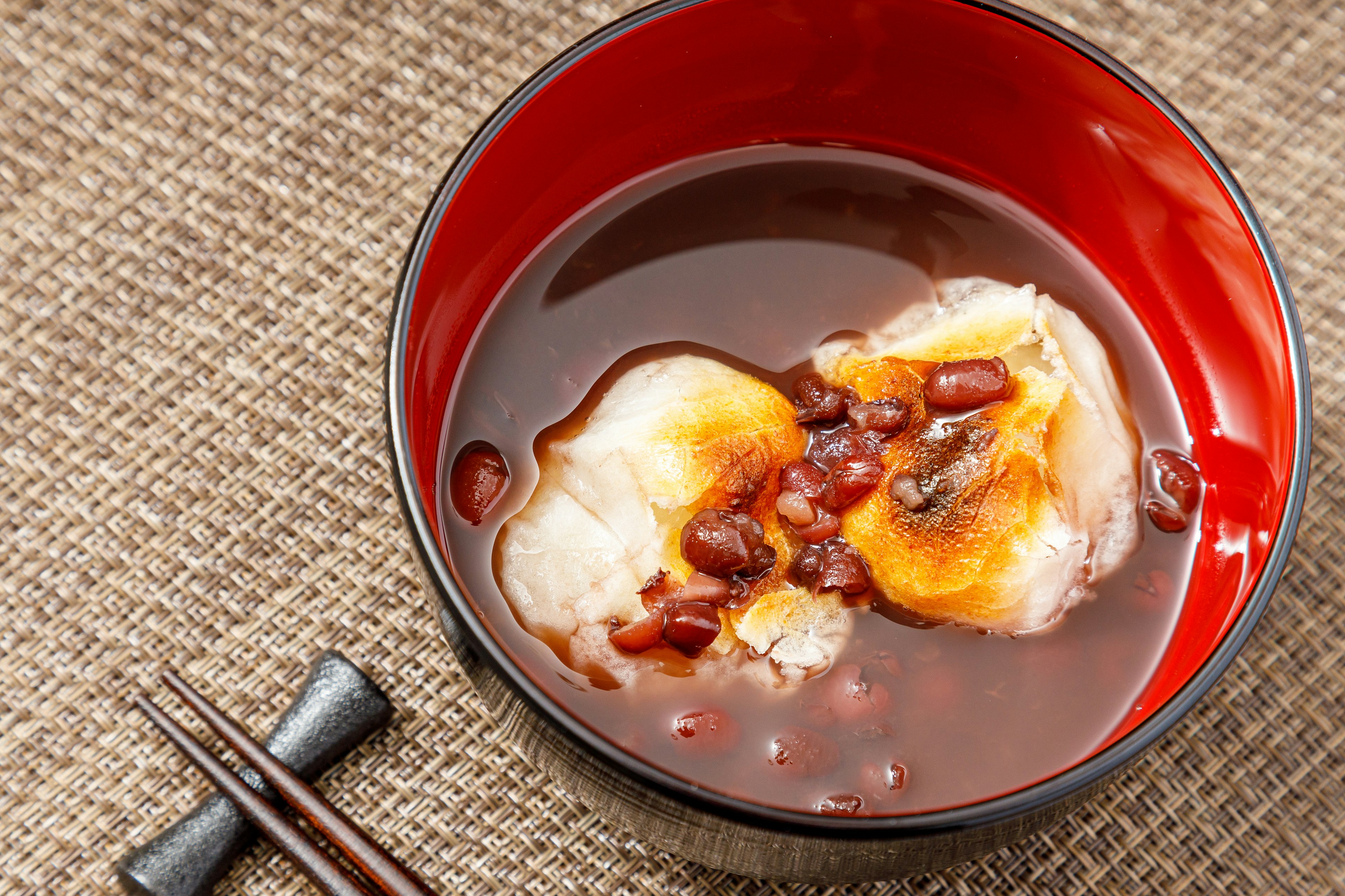 Cuenco rojo con mochi y sopa de frijoles rojos