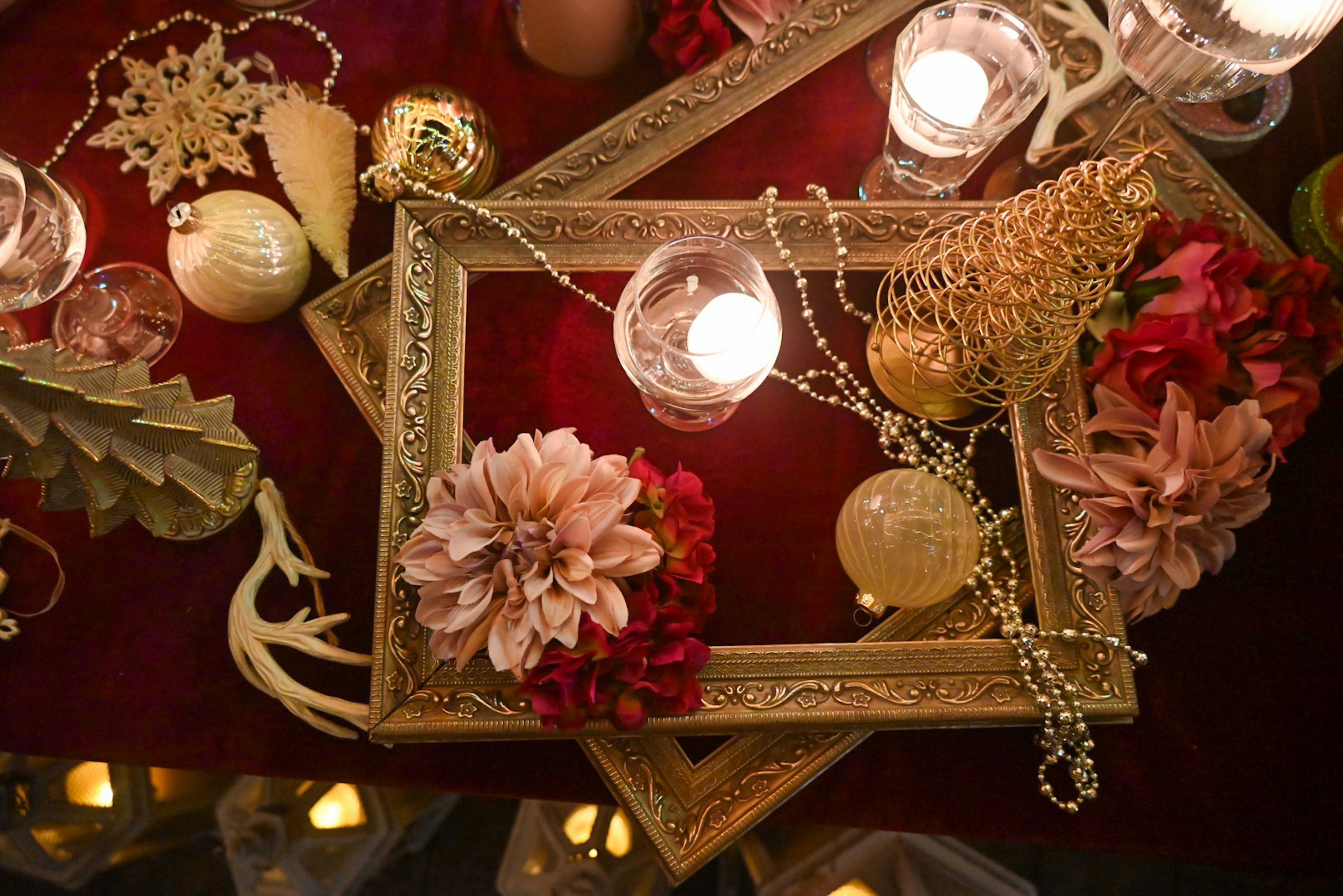 Decorative frames and floral arrangements on a red fabric background