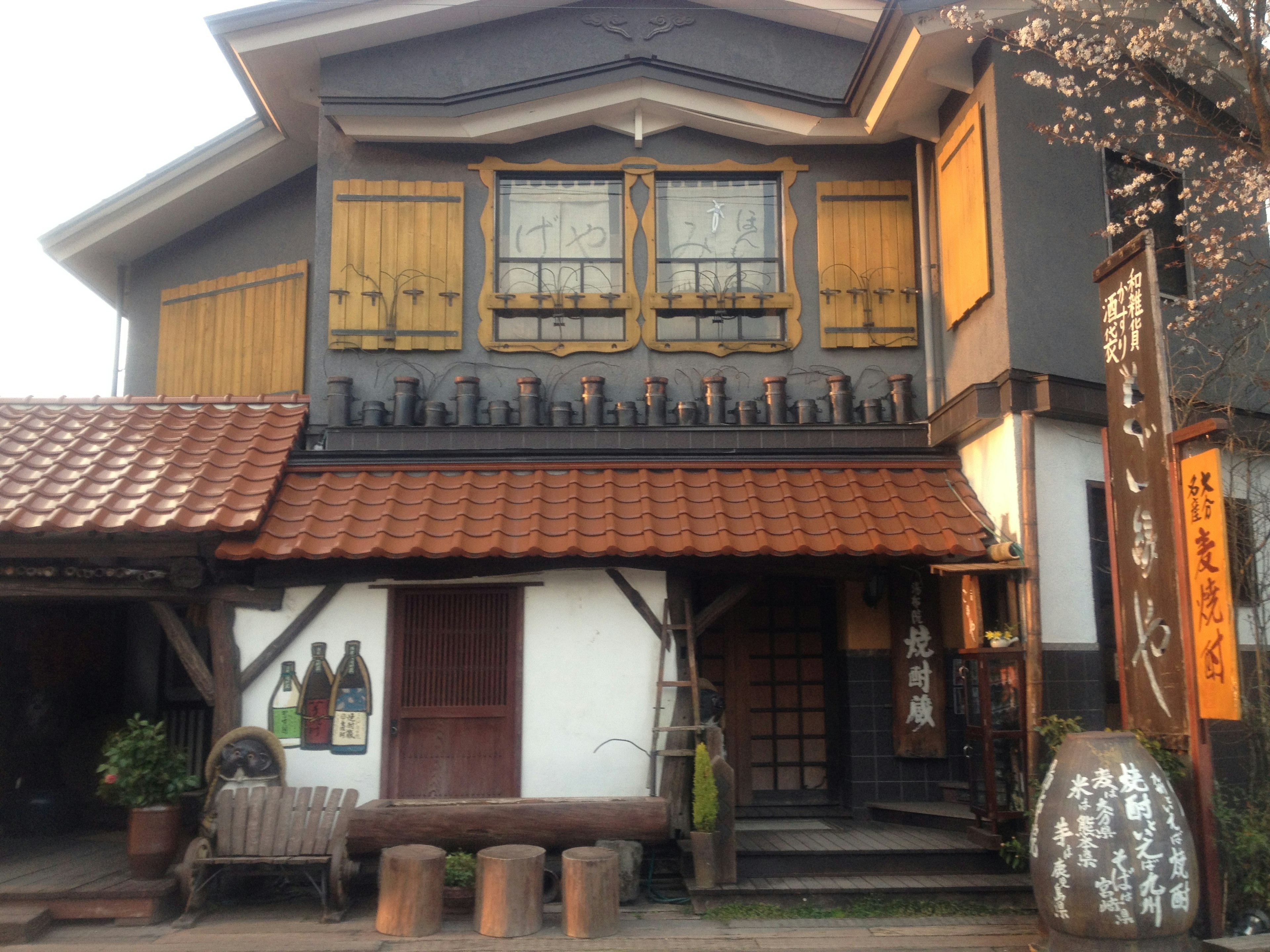 Bâtiment de style japonais traditionnel avec un toit en bois et des fenêtres aux tons chauds